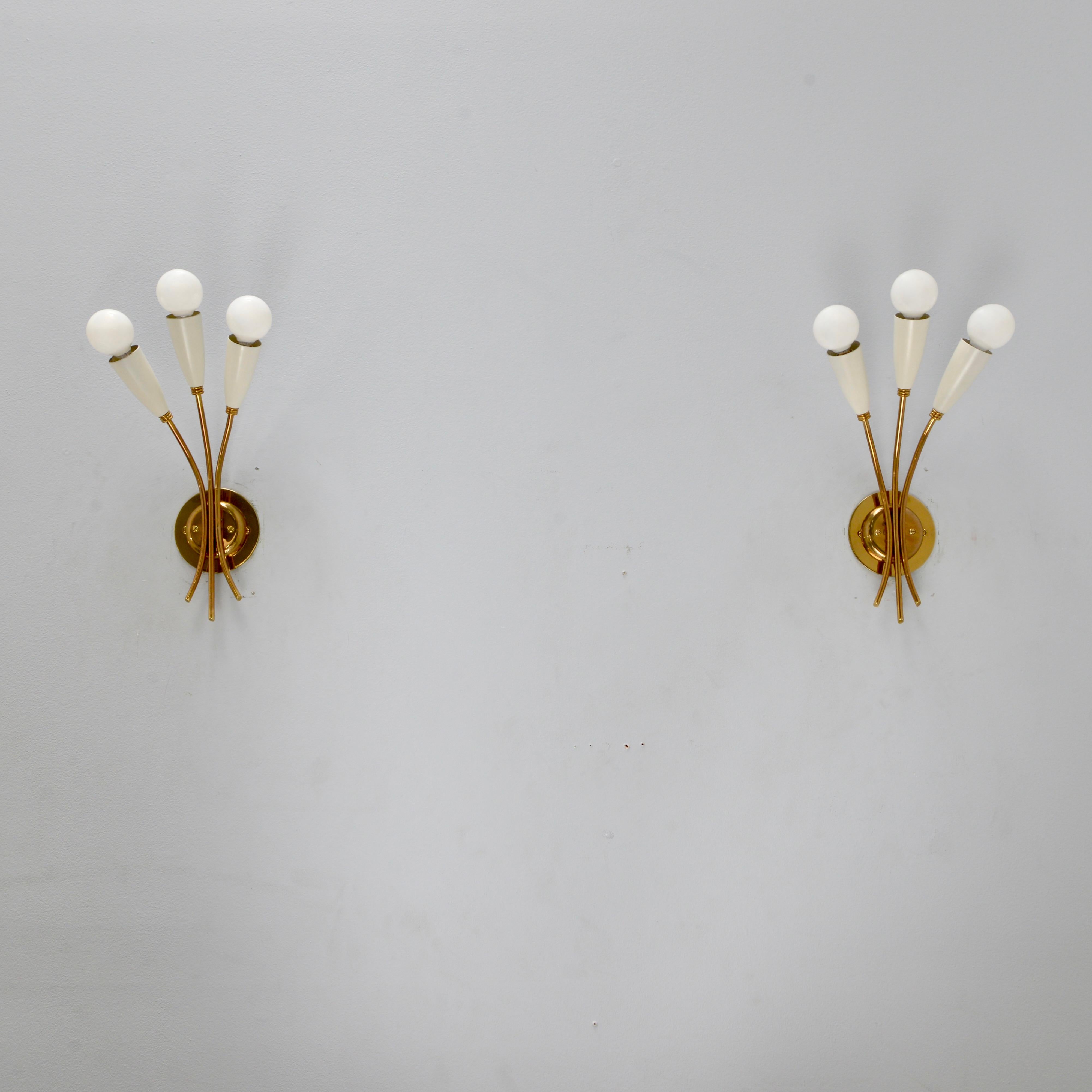 Pair of midcentury Italian 3 arm off-white botanical sconces from the 1950s. These sconces have a lightly patinated brass, and painted aluminum socket cups. Original finish. They are restored with wiring of 3 E12 candelabra based sockets per sconce,