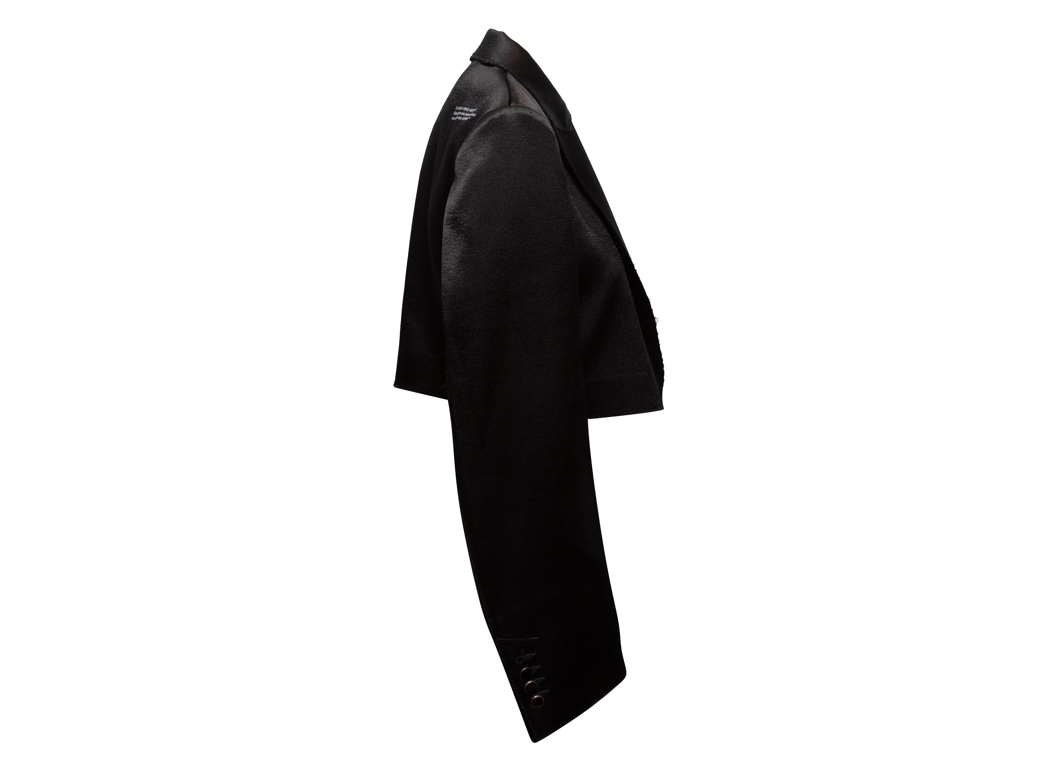 Product Details: Black cropped satin blazer by Off-White. Circa 2013. Peaked lapel. Single bust pocket. Front concealed closure. 36
