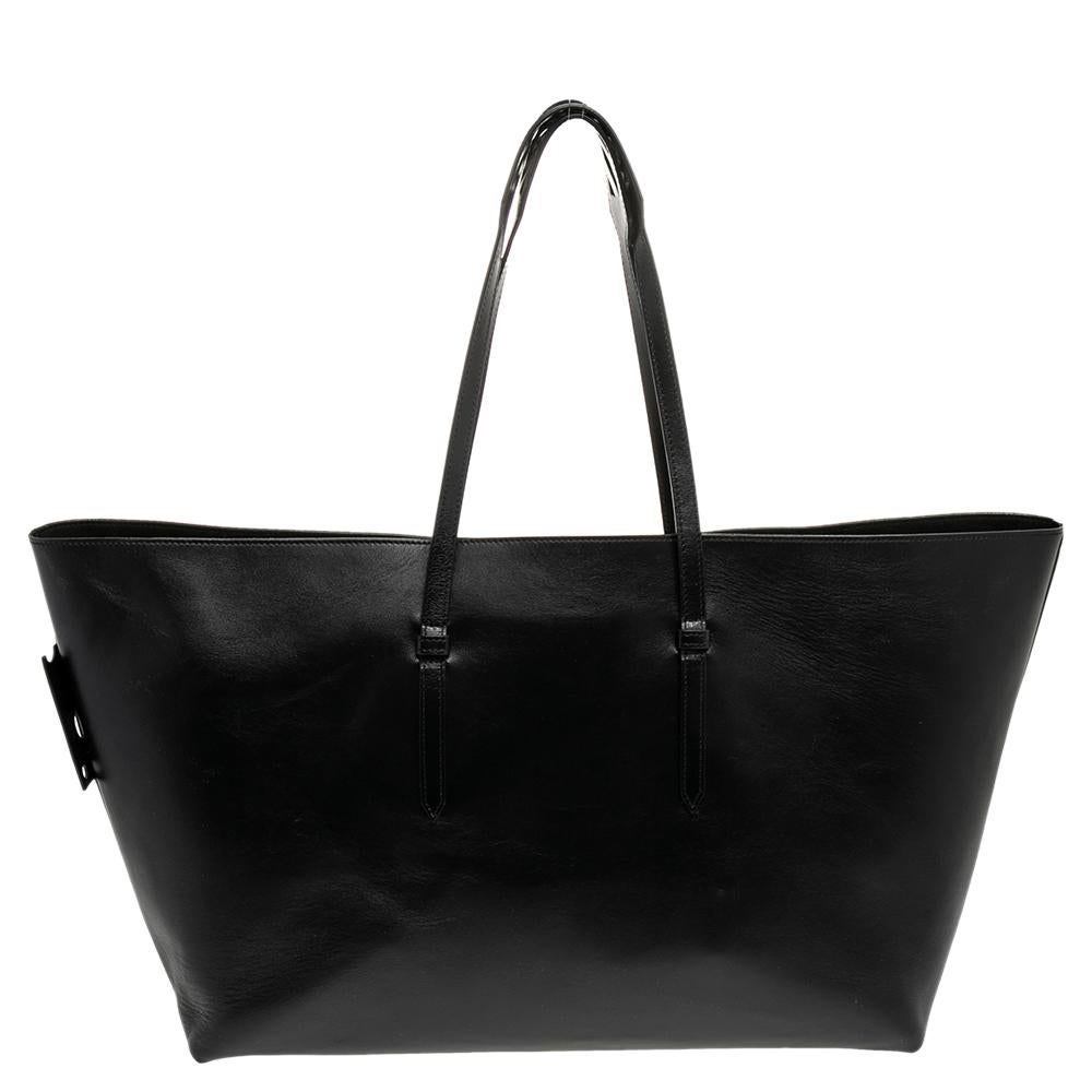 Incredibly stylish and statement-making, this tote bag from Off-White is sure to be an amazing buy! The black creation is crafted from leather and styled with a binder clip clasp on the front. It is held by dual handles and opens to an