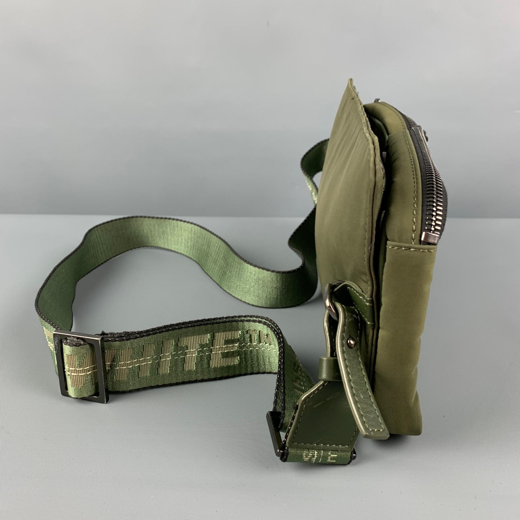 OFF-WHITE by VIRGIL ABLOH belt-bag comes in a olive nylon featuring detachable front pockets, signature logo strap, leather trim, and a zipper closure. Made in Italy. 

Good Pre-Owned Condition. Light discoloration at back.