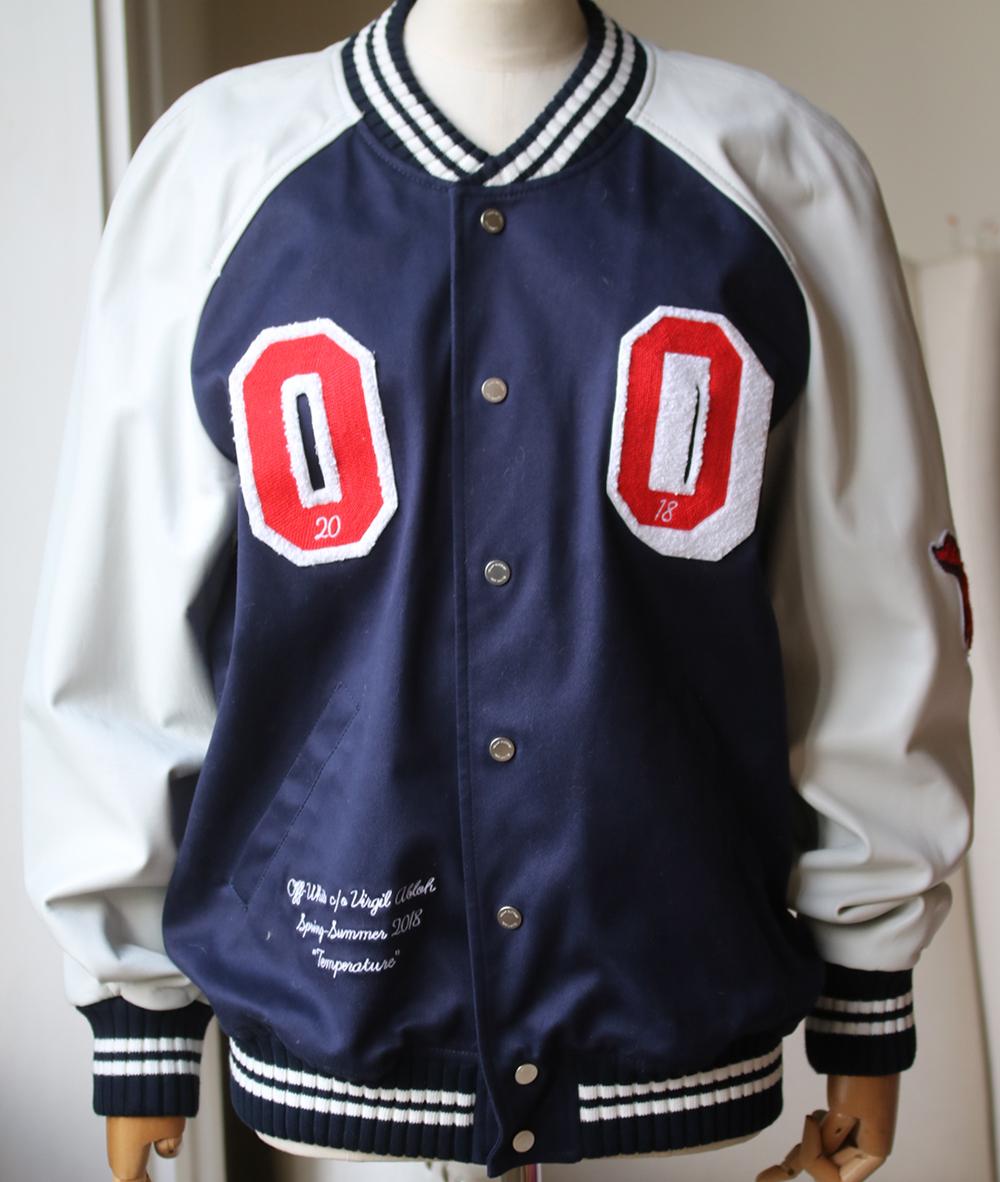 This navy and white cotton blend and lambskin varsity jacket from Off-White. Features a ribbed collar, long length raglan sleeves, a front button fastening, a ribbed hem and embroidered logo at the back. 93% Cotton, 3% elastane. 100% Lamb Skin