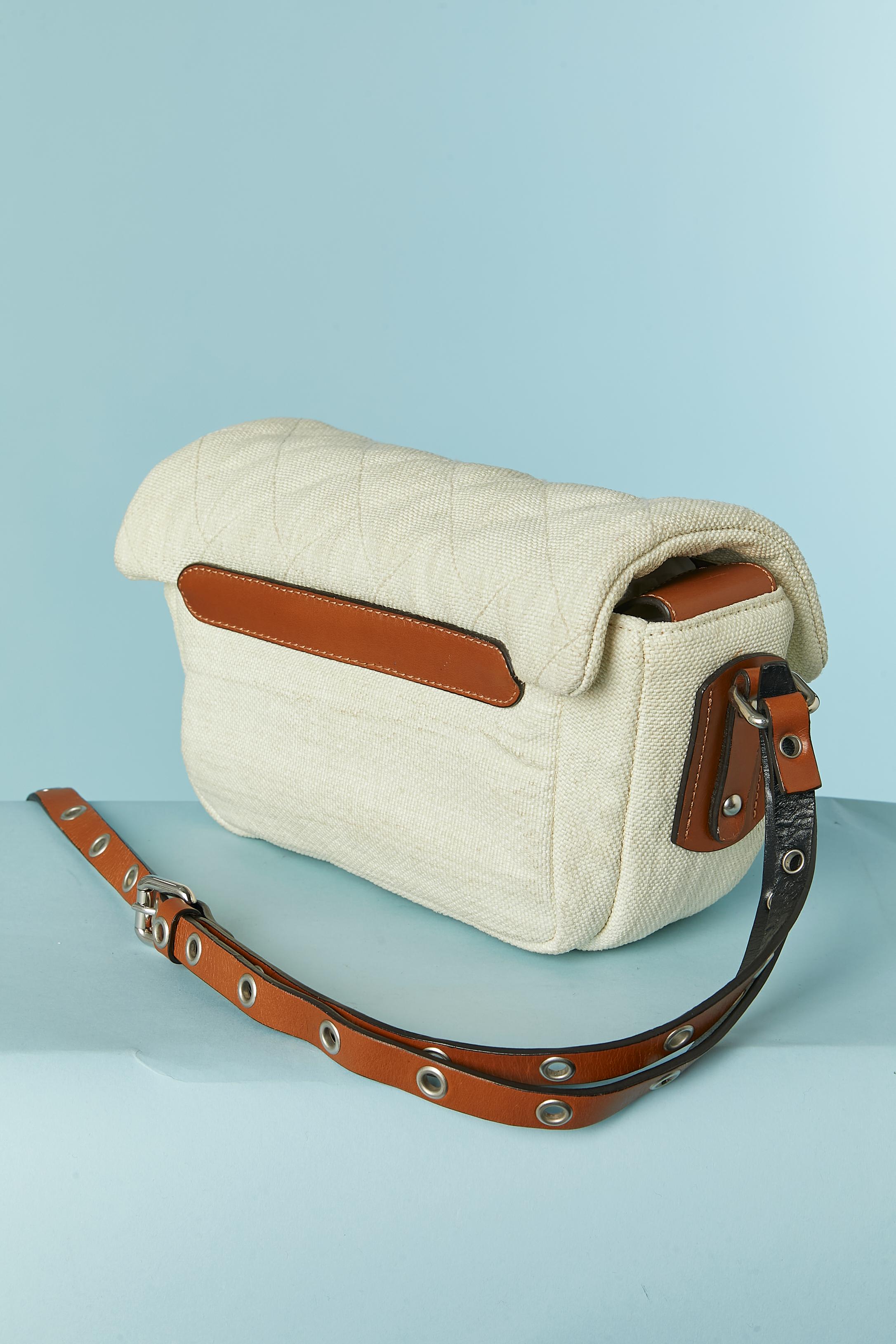 Off-white canevas and brown leather crossbody bag. Fabric composition: 60% polyamide ( nylon) 40% cotton. Lining: 100% cotton. 
Snap closure under the top flap. 2 flat pockets inside. 
SIZE: 30cm X 16cm X 6cm 
Crossbody strap lenght: 140cm (