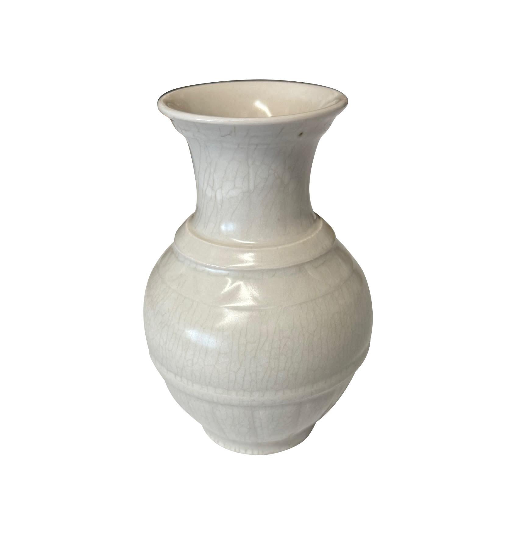 Vaso cinese contemporaneo in bianco sporco smaltato a crepe.
Design a coste verticali alla base.
Fa parte di un'ampia collezione di piccoli vasi di colore bianco sporco delle stesse dimensioni.
Ottimo per le librerie.