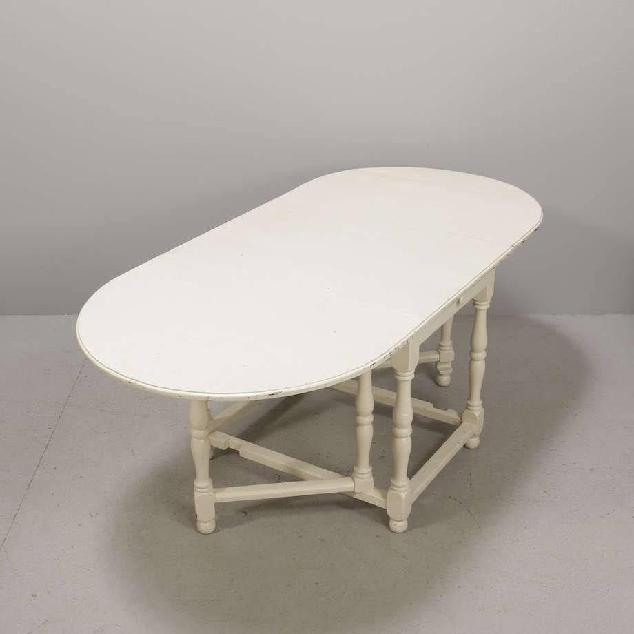 Gateleg farm table from 1900s, later painted a creamy Scandinavian off-white, extendable to a large oval dining table. Turned legs, single drawer on either side, sturdy base, wonderful patina.

Measures: H 30