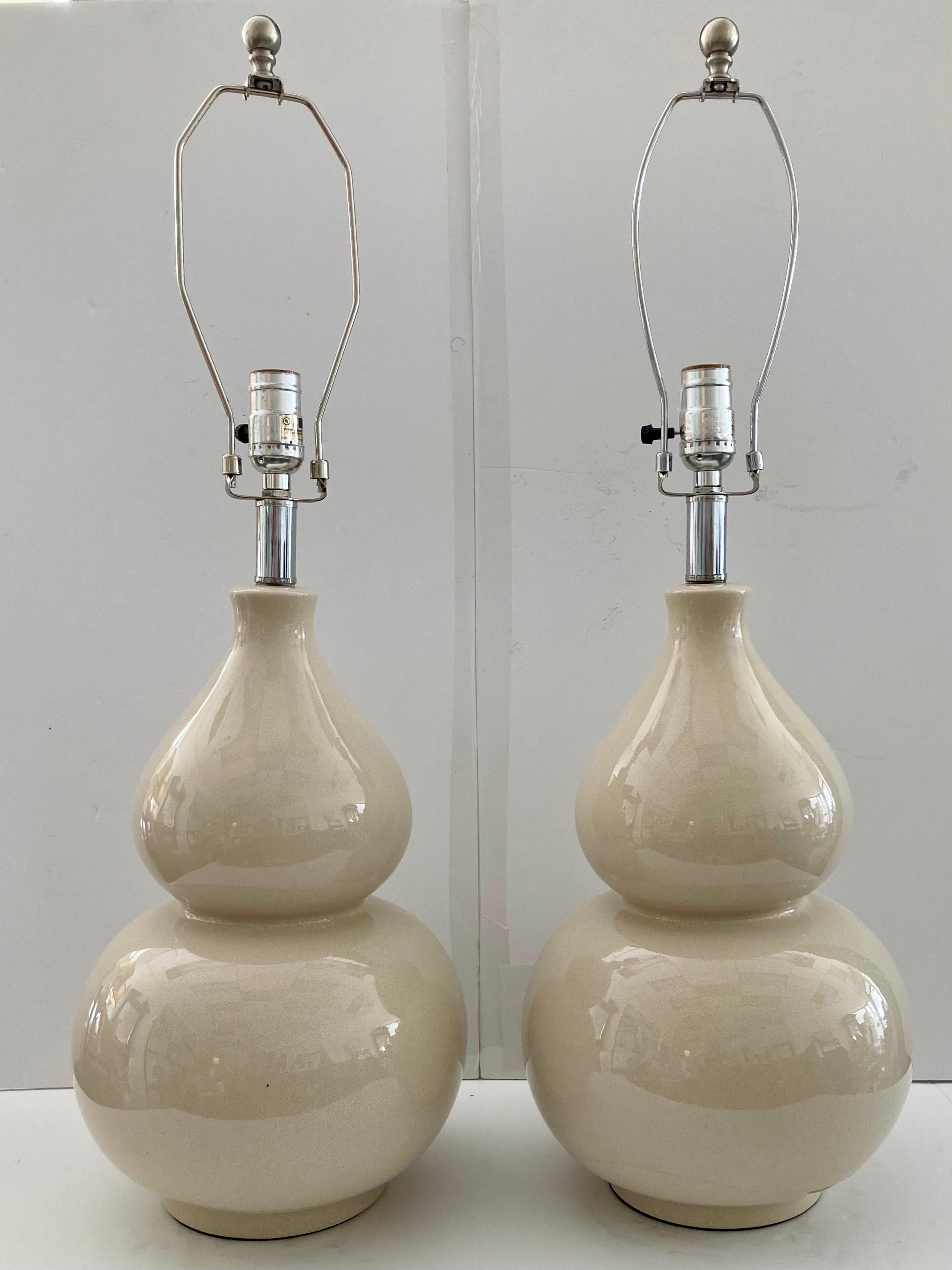 Magnifique paire de lampes de table en forme de gourde en céramique émaillée blanc cassé. Ajoutez un style traditionnel à votre intérieur avec ces magnifiques lampes de table en forme de gourde en céramique émaillée blanc cassé. Forme classique, il