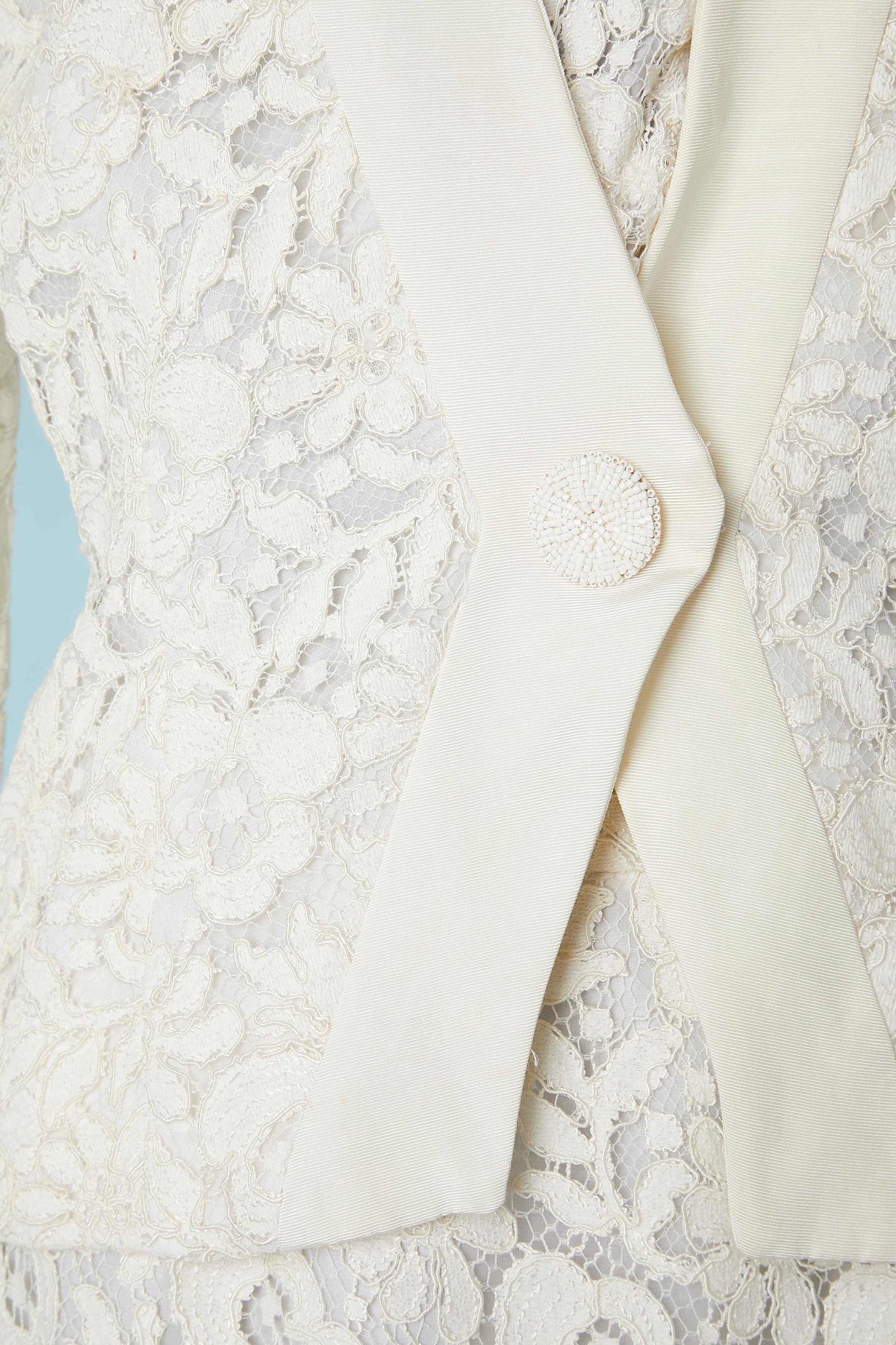 Gonna-suit in guipure bianco sporco. Spallaccio. Bottone decorativo con perline bianche. 
Taglia 10 (L) 
