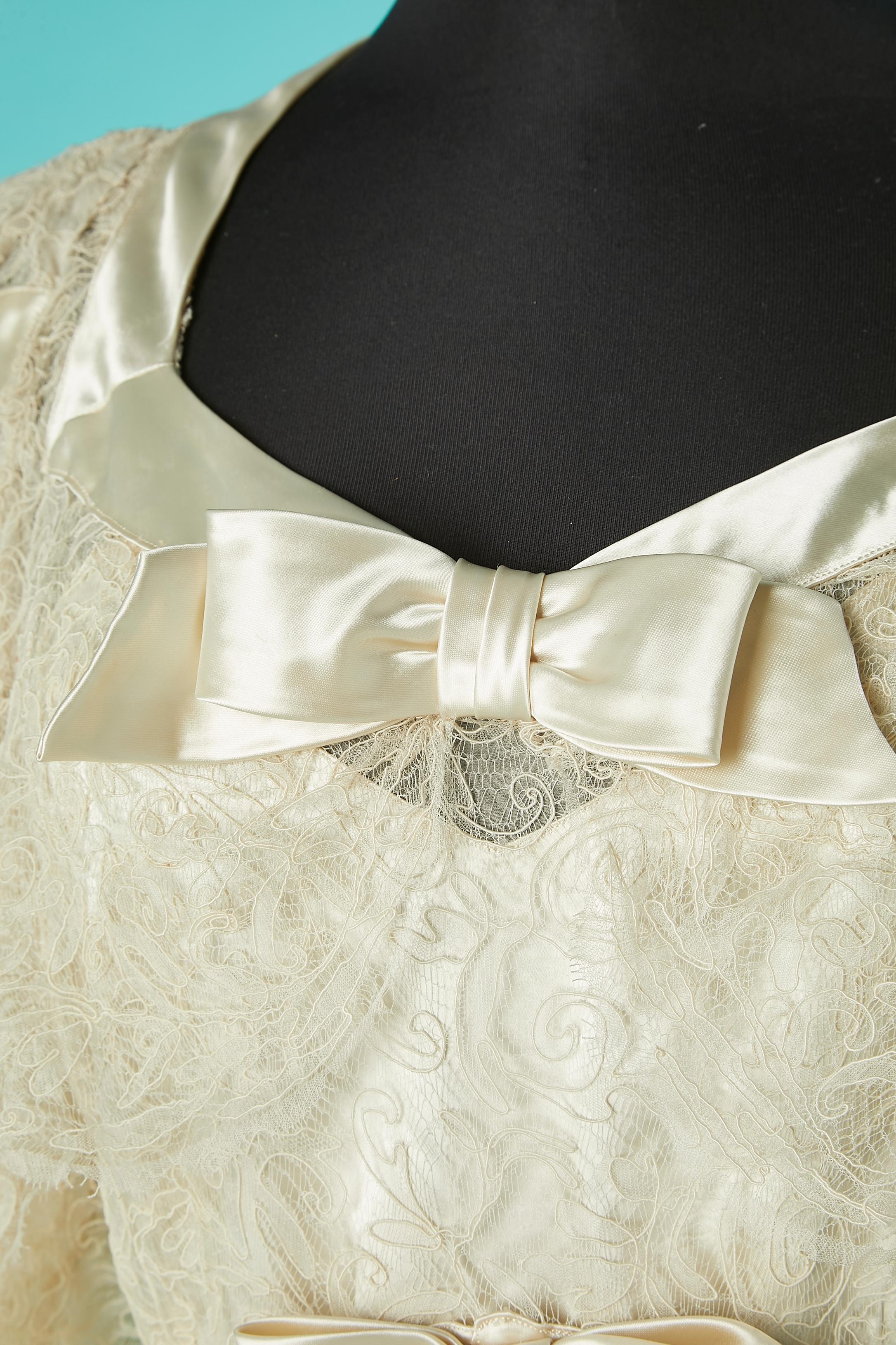  Weißes Hochzeitskleid aus Spitze und Satinschleife mit Druckknopfverschluss auf der linken Seite. Satinfutter mit Reißverschluss auch auf der linken Seite. 
Gesamtlänge vorne: 160 cm
Gesamtlänge im Rücken : 175 cm 
SIZE 40 (Fr) M/L 