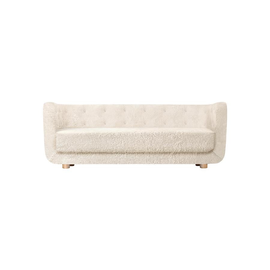 Off White sheepskin and natural oak Vilhelm sofa by Lassen.
Dimensions: W 217 x D 88 x H 80 cm. 
Materials: sheepskin, oak.

Vilhelm is a beautiful padded three-seater sofa designed by Flemming Lassen in 1935. A sofa must be able to function in