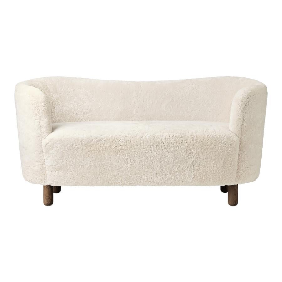 Off white sheepskin and smoked oak mingle sofa by Lassen
Dimensions: W 154 x D 68 x H 74 cm 
Materials: Sheepskin, oak.

The Mingle sofa was designed in 1935 by architect Flemming Lassen (1902-1984) and was presented at The Copenhagen
