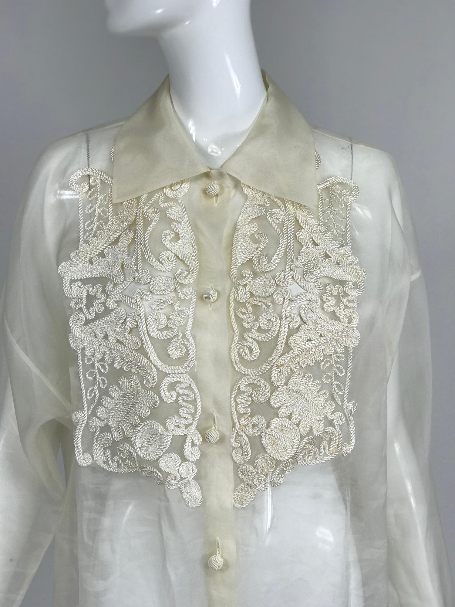 Off white sheer silk organza passementerie long sleeve tunic blouse from the 1990s. This beautiful blouse is very sheer and see through, you may want add a camisole. The cord work passementerie forms a bib front. The blouse closes with cord work