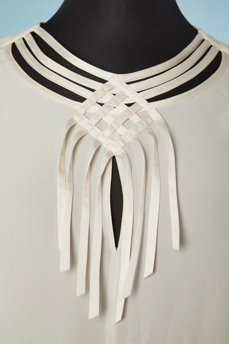 Off-white Seidenbluse mit Cut-work am Halsausschnitt und an den Manschetten. 2 Knöpfe in der hinteren Mitte und je 2 an den Manschetten. 
GRÖSSE 42 