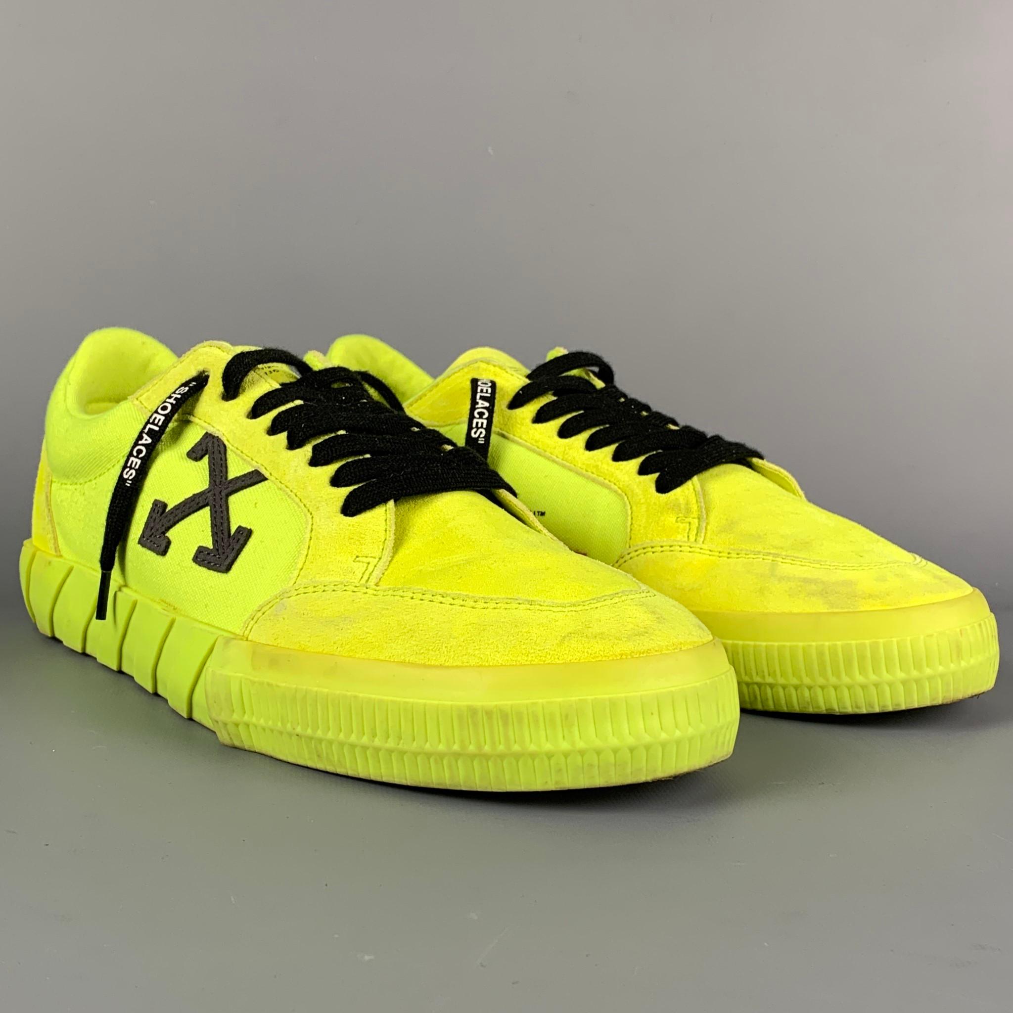 OFF-WHITE by Virgin Abloh 'Low Vulcanized Fluo Yellow' sneakers comes in a neon yellow suede featuring a low top style, embroidered black arrows, rubber sole, and a lace up closure. Made in Italy.

Good Pre-Owned Condition. Light wear at