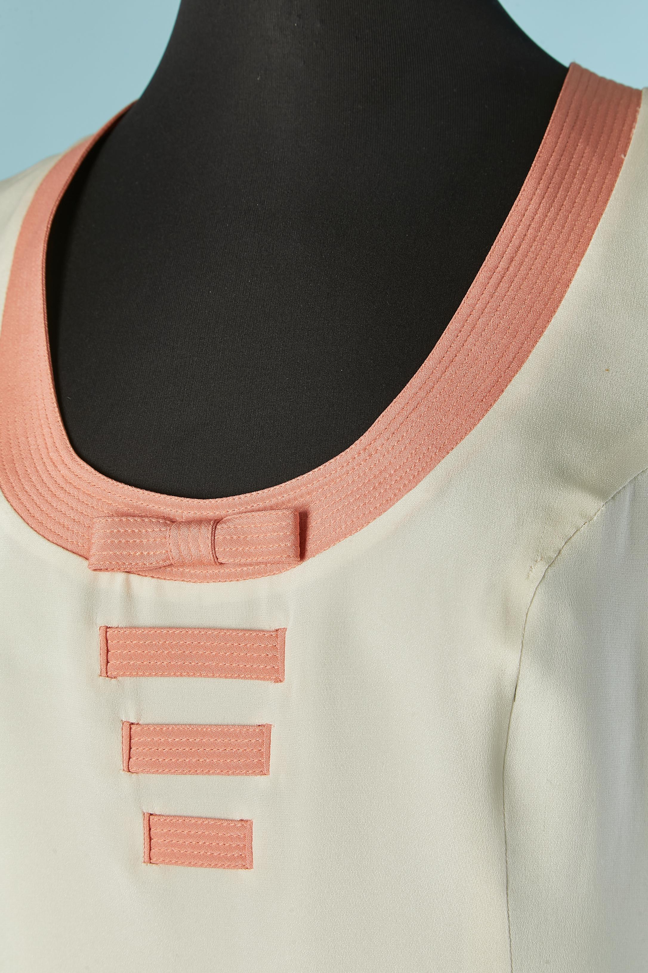 Ärmelloses, cremefarbenes Top mit abgesteppter rosa Schleife am Ausschnitt. Zusammensetzung des Stoffes: 63% Seide, 37% Polyester. Auskleidung.
Unsichtbarer Reißverschluss auf der linken Seite. 
GRÖSSE M 