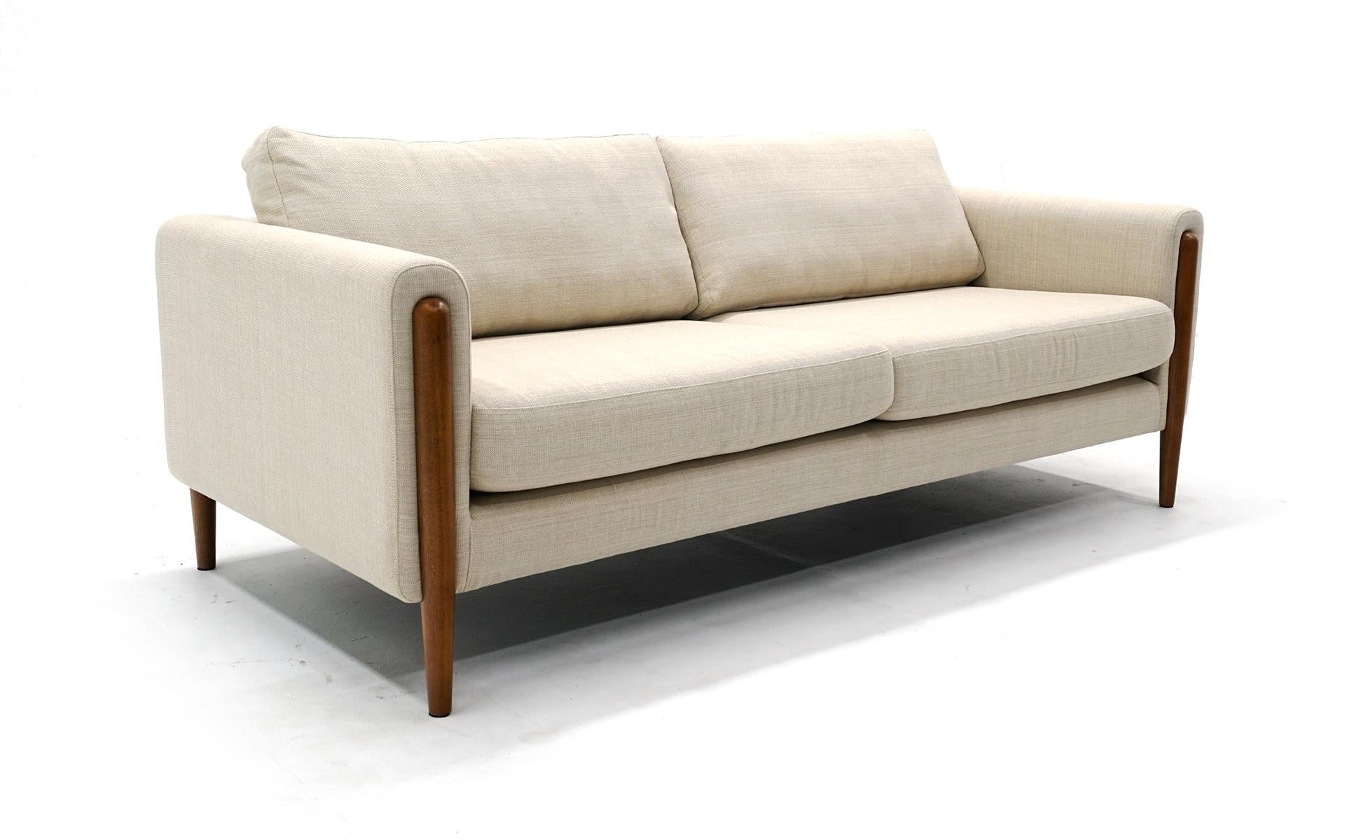 Six and a half foot off white / cream color sofa made by Neuvo. This was original purchased to stage a home for sale and is virtually unused. No signs of wear to the fabric. There may be some imperfections in the walnut upon very close inspection