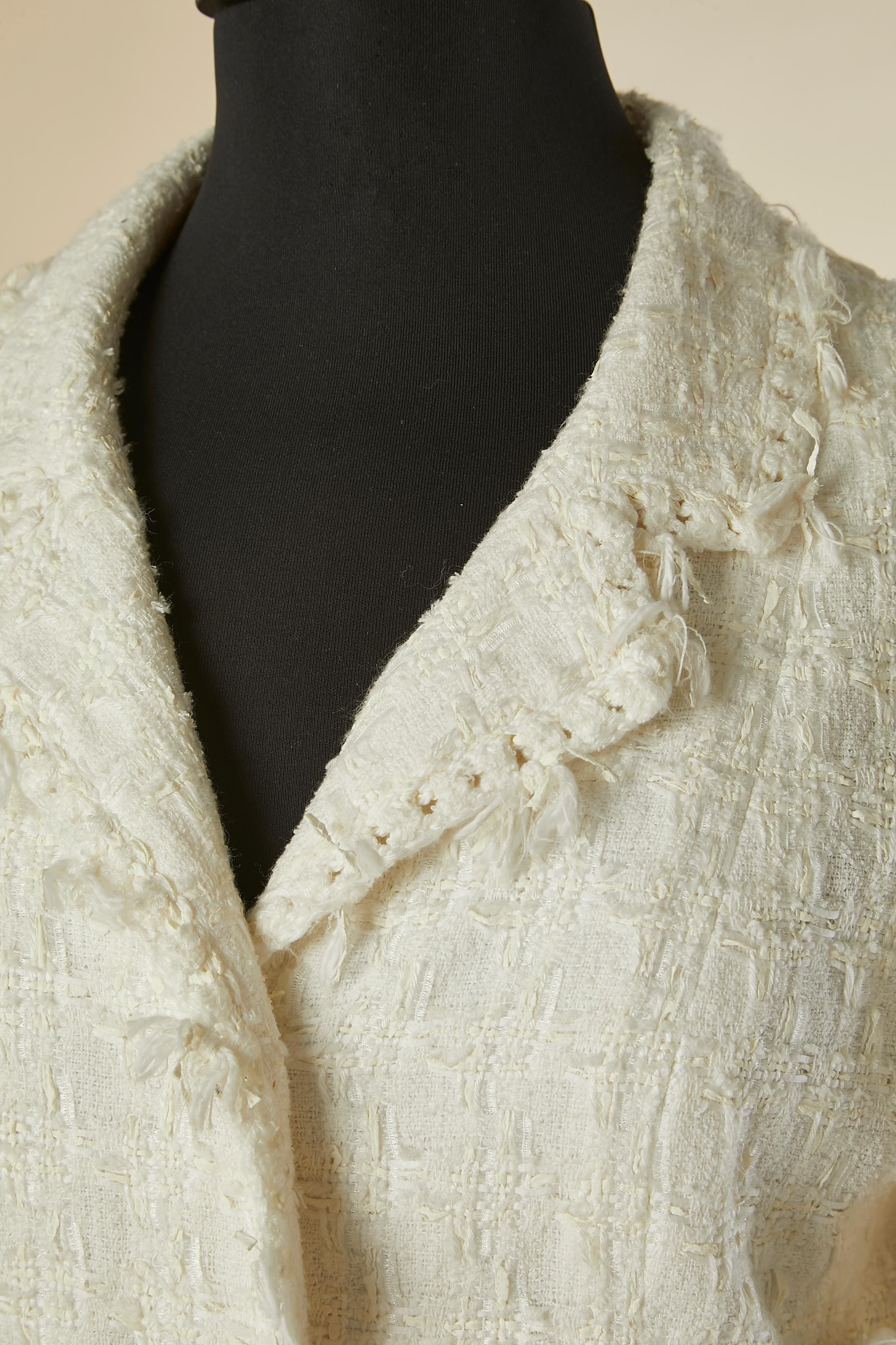 Veste en tweed blanc cassé à simple boutonnage. 
Composition du tissu principal : 52% coton, 16% rayonne, 12% acrylique, 9% polyuréthane, 8% polyester, 3% laine. Doublure en soie et élasthanne (3%). Fermeture par boutons et boutonnières sur le