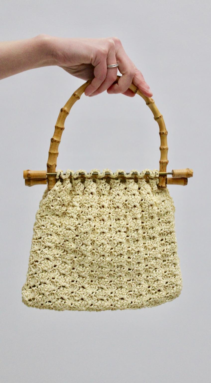 This bamboo handle bag was designed and made in the 1960s. The handle bag features a beautiful crochet  body and it is inside lined. 
Furthermore the closure is very interesting. You close the bag with moving the brass rods.
The vintage condition is