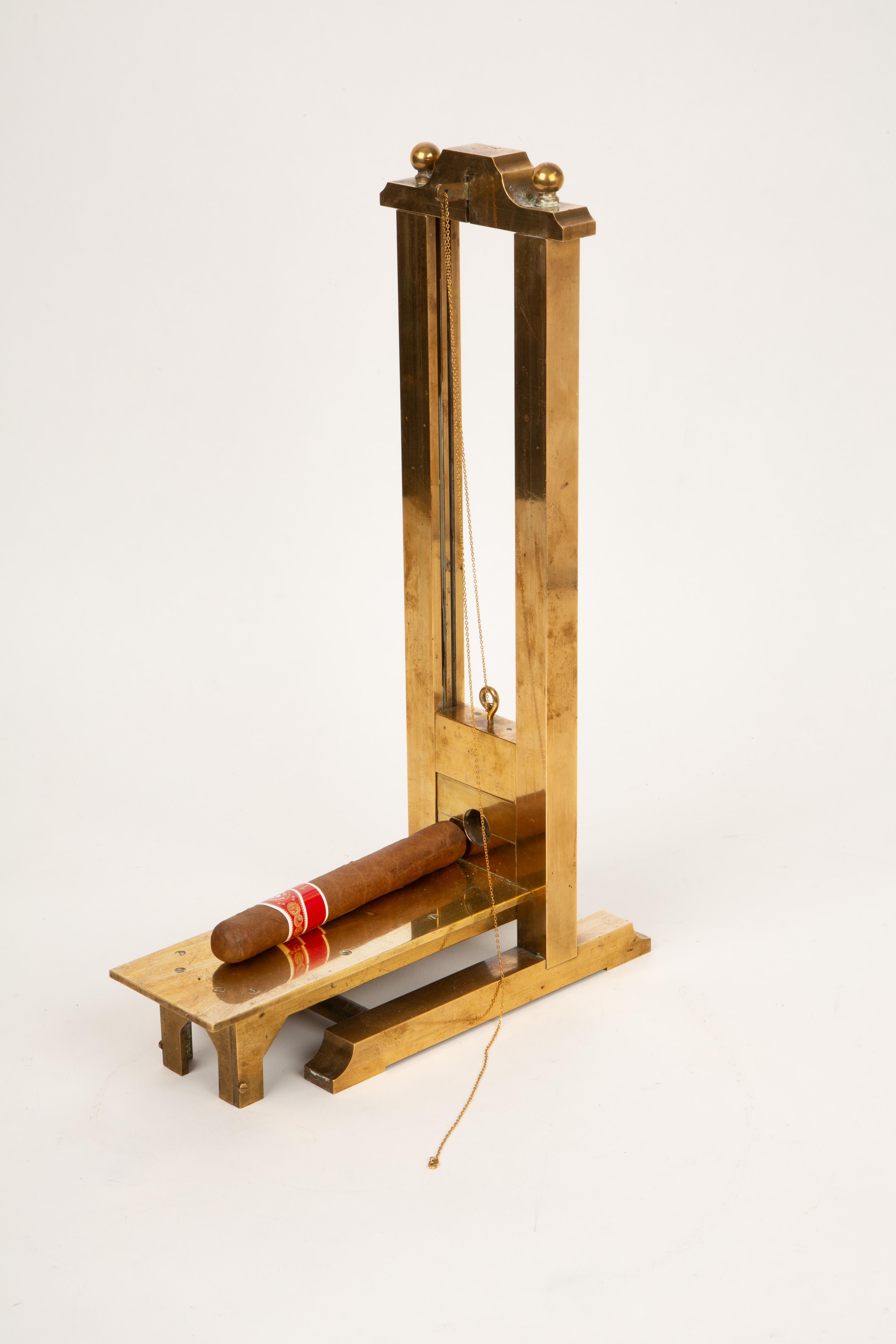 **Early 20th-Century Brass Guillotine Cigar Cutter**  
Why settle for a boring cigar cutter when you can channel the drama of the French Revolution every time you light up? This early 20th-century brass guillotine cigar cutter, crafted by masterful