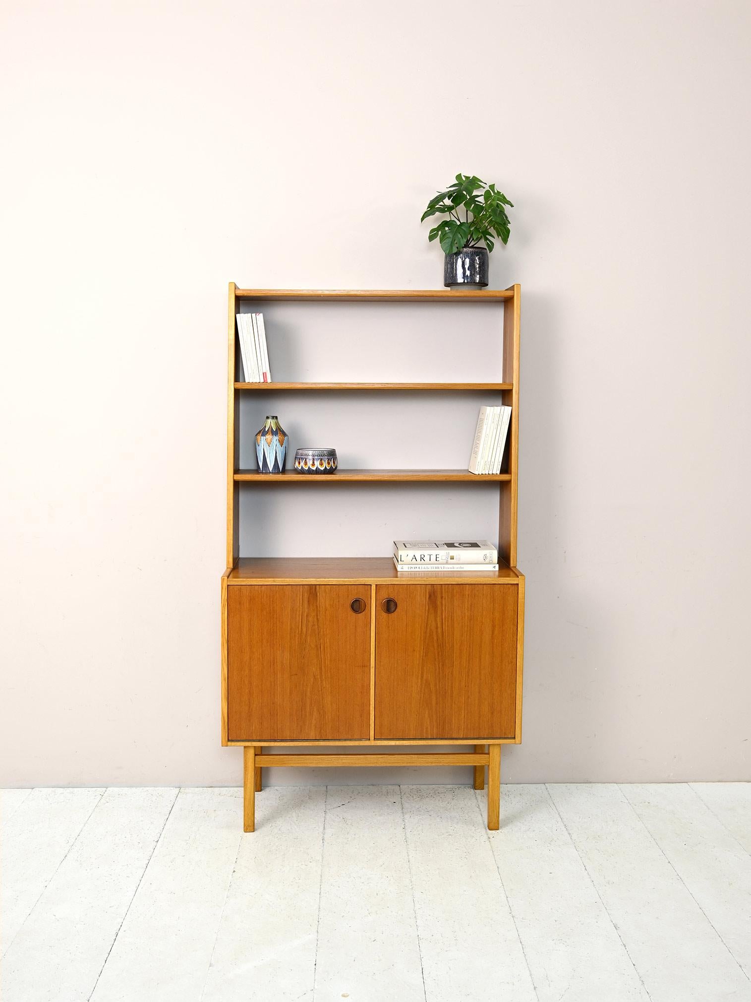 Vintage 1960s Scandinavian cabinet made of teak and oak.

An original piece of furniture whose special feature is the drop-down opening of the doors. The cabinet was originally conceived as office furniture and thus consists of a filing cabinet