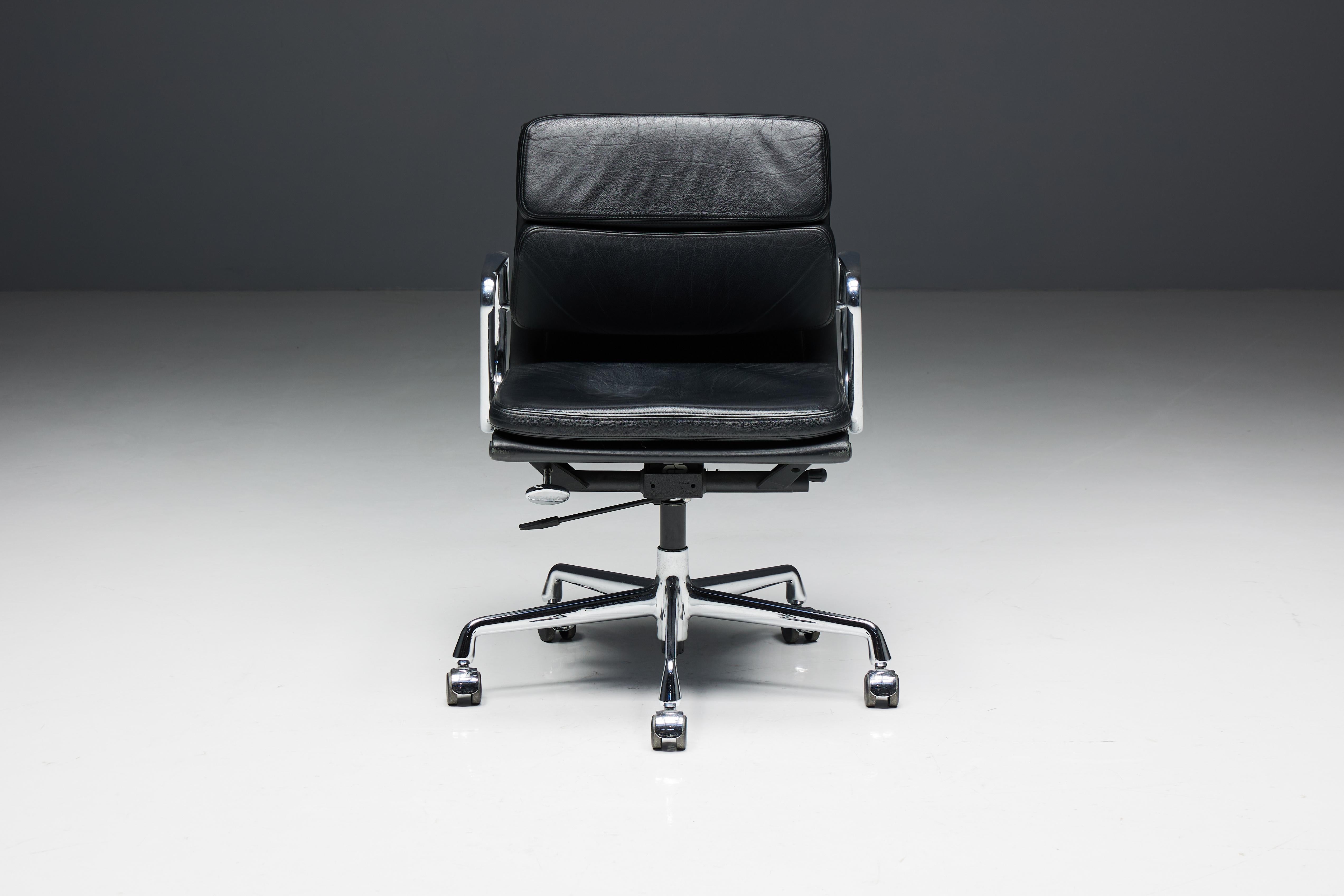Charles and Ray Eames EA217 softpad office chair, produced by Vitra. This distinguished chair boasts a sleek black leather seat and backrest, complemented by a chrome frame and armrests for a timeless aesthetic. It features swivel, mobile,