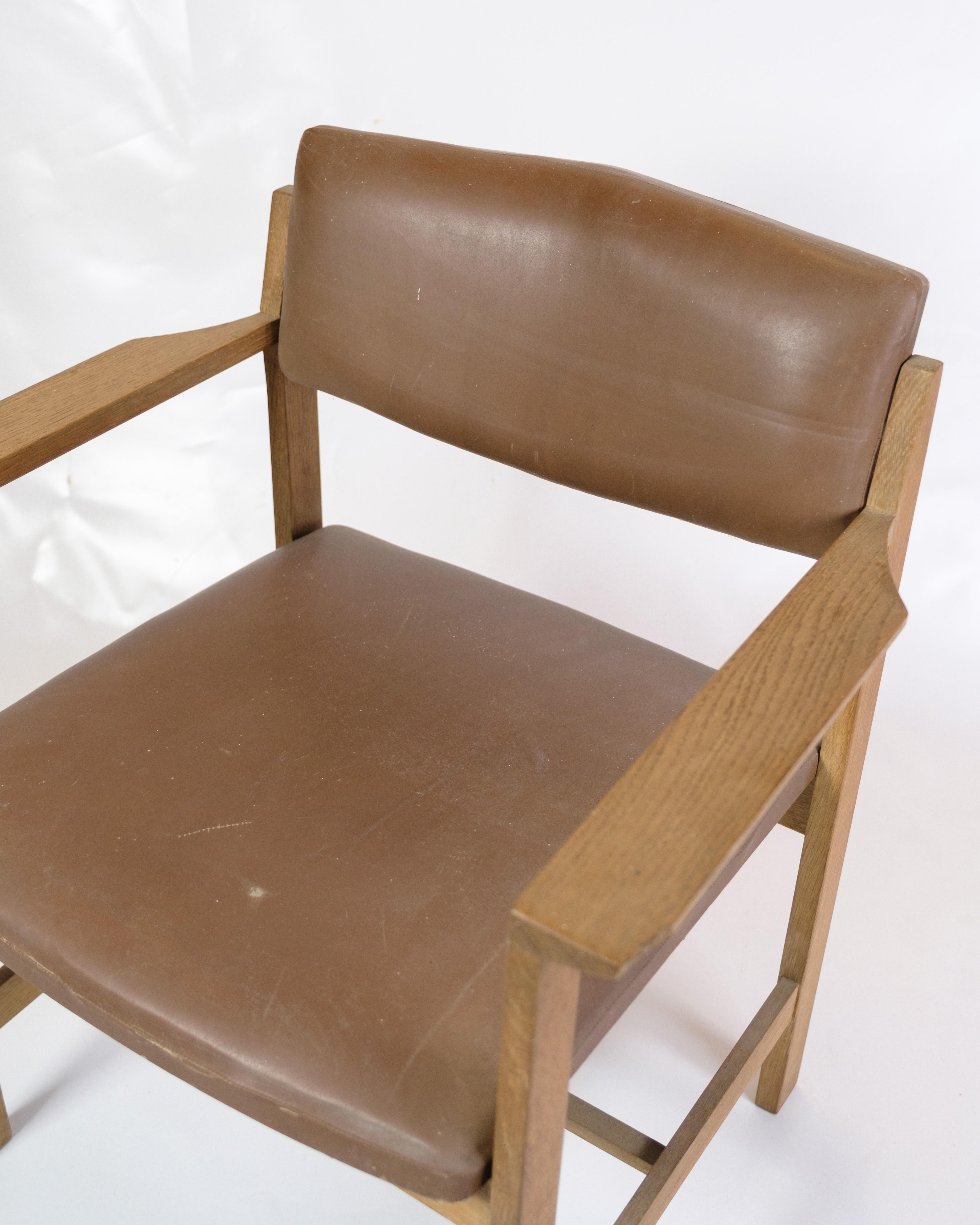 Bürostuhl aus dem Jahr 1970, aus robustem Eichenholz gefertigt und mit braunem Leder gepolstert. Dieses zeitlose Design bringt einen Hauch von Eleganz in jedes Büro oder Studio. Mit seinem ergonomischen Design und den langlebigen Materialien ist er