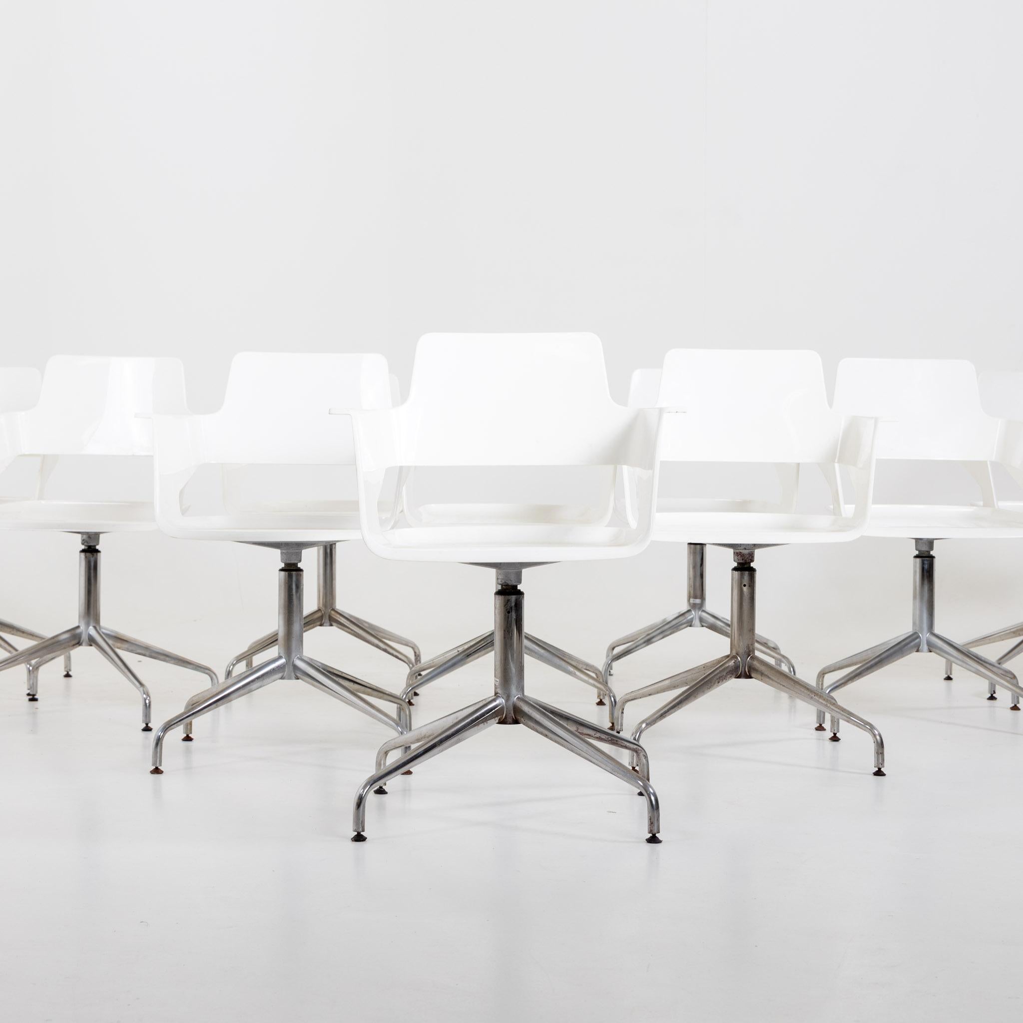 Ensemble de dix chaises de bureau sur pieds métalliques et coques d'assise blanches avec accoudoirs. Les chaises présentent un design moderne avec des pieds métalliques élégants et des coques d'assise ergonomiques blanches, offrant à la fois style