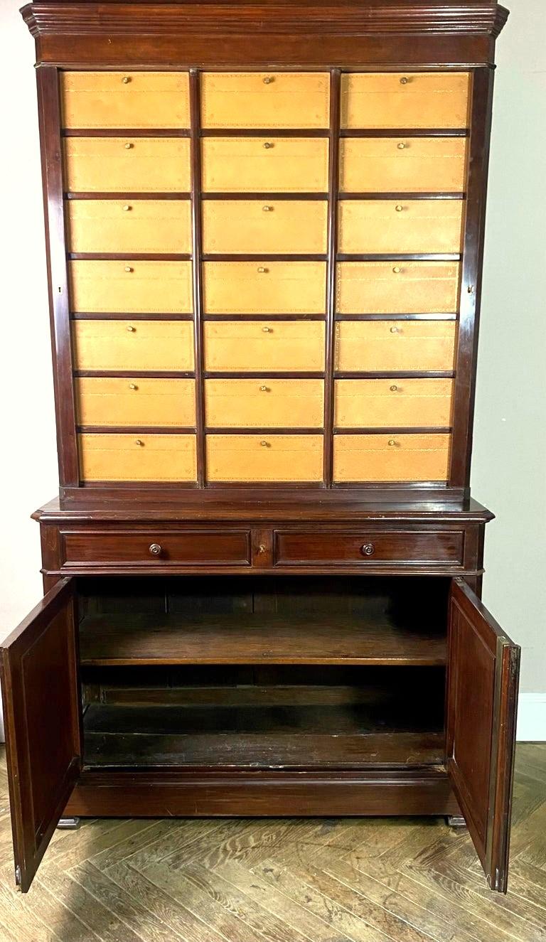 Magnificent notary's cartonnier / office filing cabinet in mahogany veneer with cardboard boxes covered in leather with iron gilding. The lower part opens with 2 doors and 2 drawers.
The cartonnier consists of 21 compartments including 21 cardboard