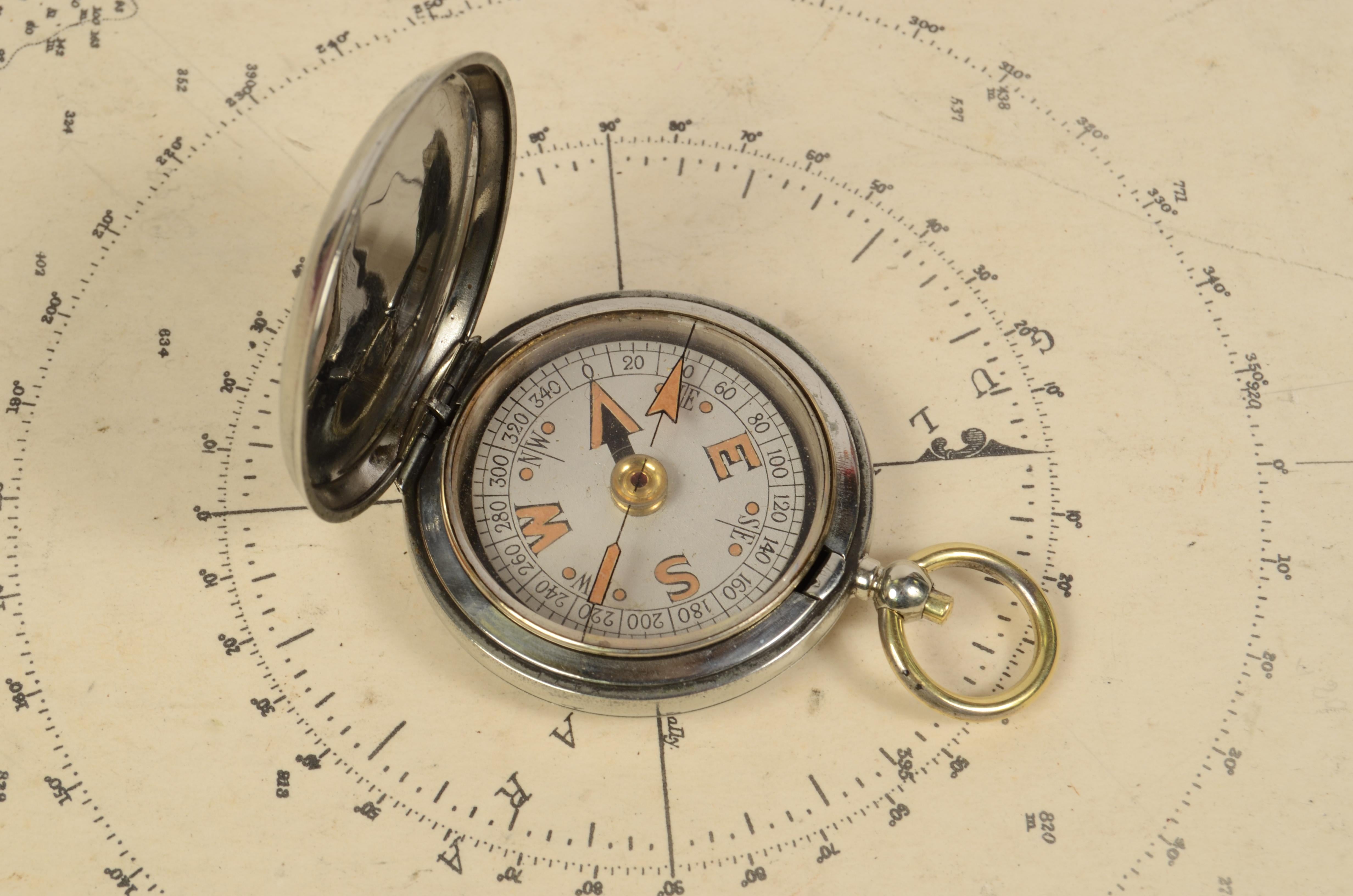 Officer pocket compass used in 1918 by British Air Force officers made of chromed brass shaped like a pocket watch. Signed Clement Clarke Ltd London VI n. 37185 1918. The compass is equipped with a lid with snap closure with release button inside