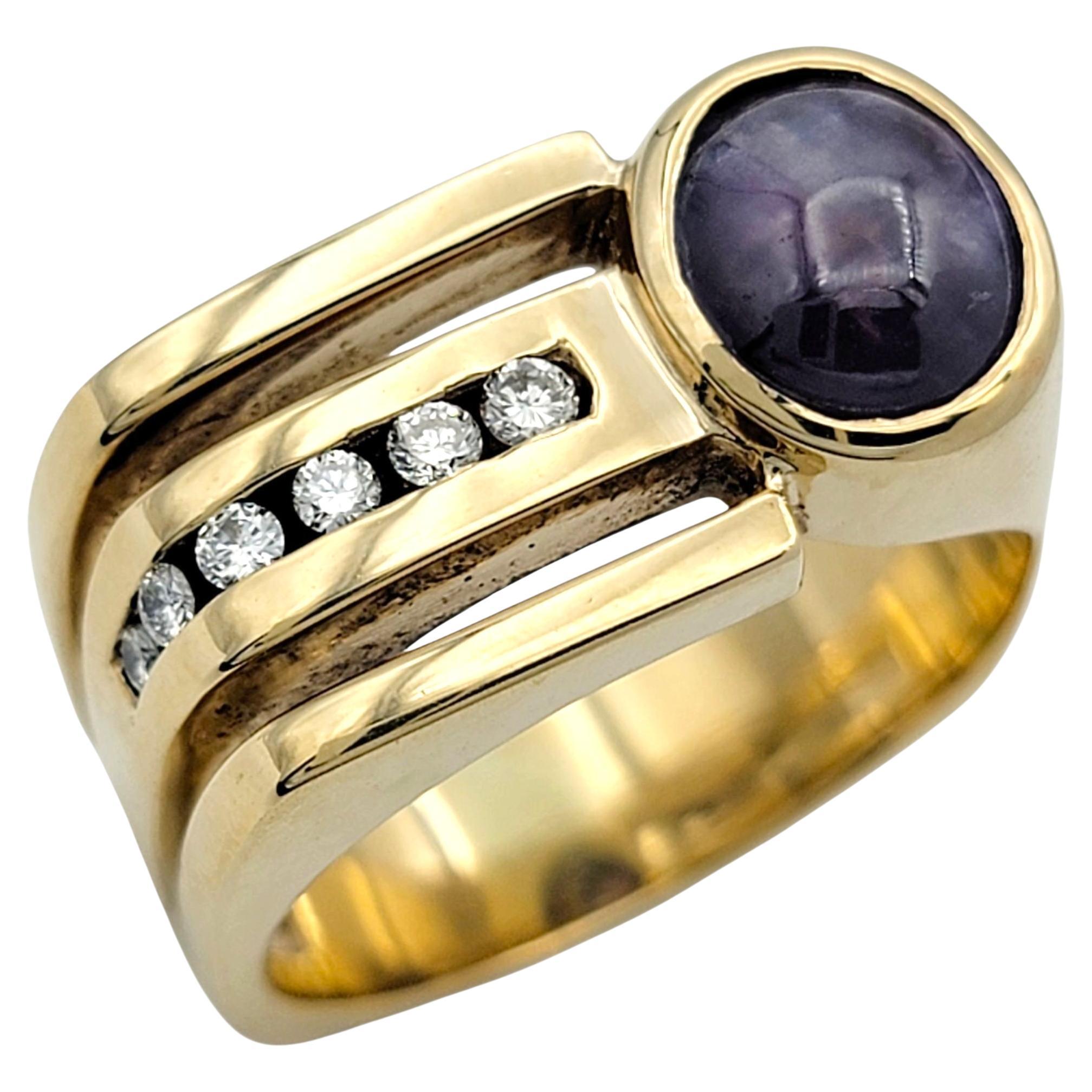 Questo audace anello presenta uno zaffiro viola tagliato a cabochon, la cui superficie liscia e il colore ricco emanano un fascino senza tempo. Il centro è impreziosito da diamanti di taglio rotondo che aggiungono brillantezza e contrasto, esaltando