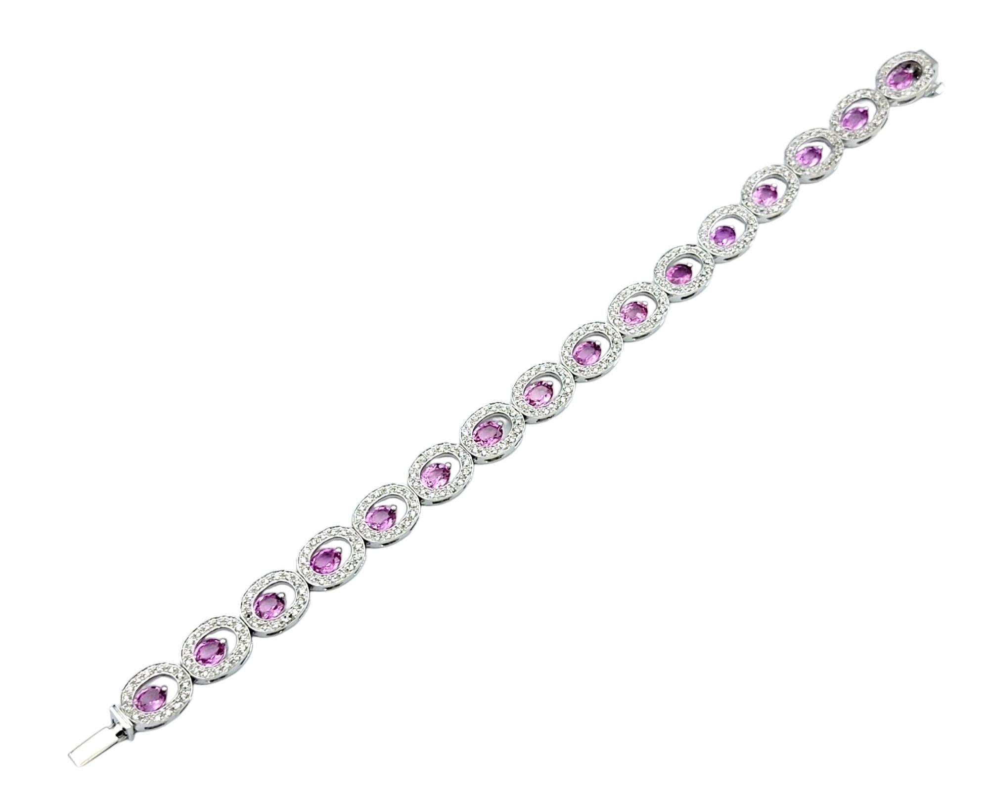 Embrace the utmost feminine elegance with this exquisite pink sapphire and diamond halo open O-link bracelet, crafted in lustrous 14 karat white gold. Each link features a delicate open circle encrusted with shimmering diamonds, with a captivating