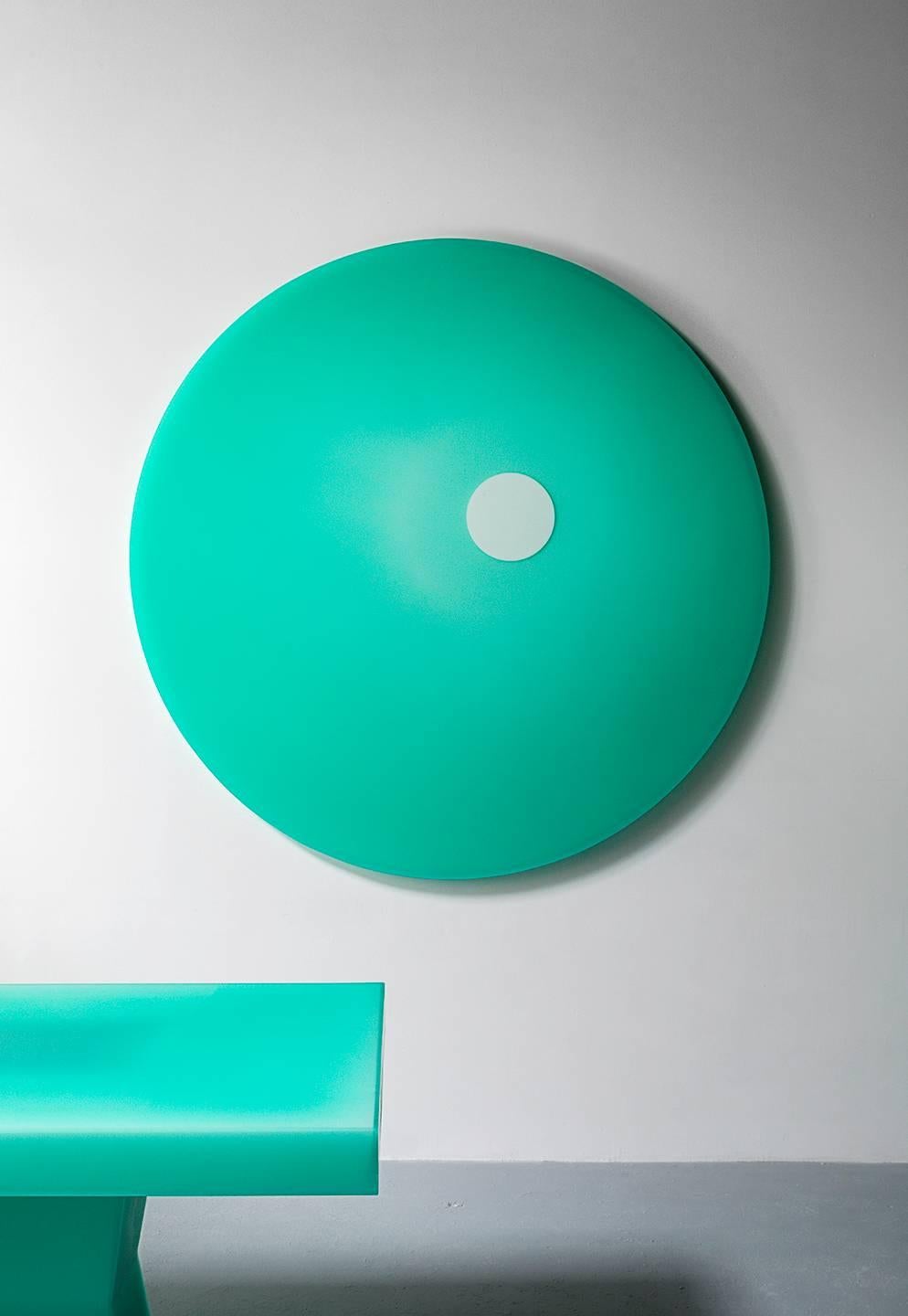 This wall piece uses Facture Studio's Shift style to transition seamlessly from a deep opaque to water clear green over a white core with an offset shift to a round almost white circle. The exterior facets are sanded to a buttery smooth finish. This