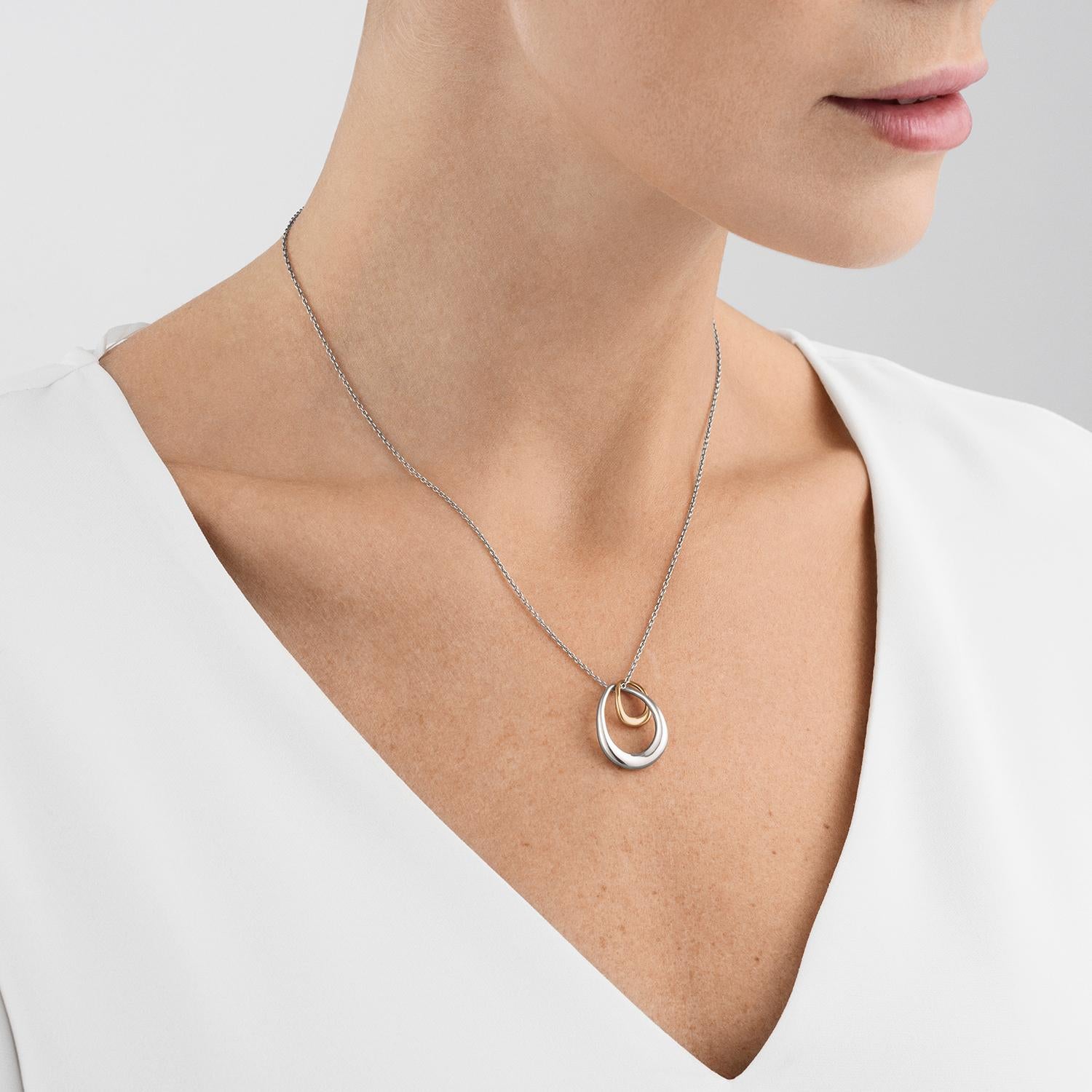 Two irregular organic shapes in silver and gold are interlocked in a form that symbolises the unbreakable bond between mother and child, lovers, friends or siblings. The Offspring necklace has a strong emotional resonance that adds an extra layer of