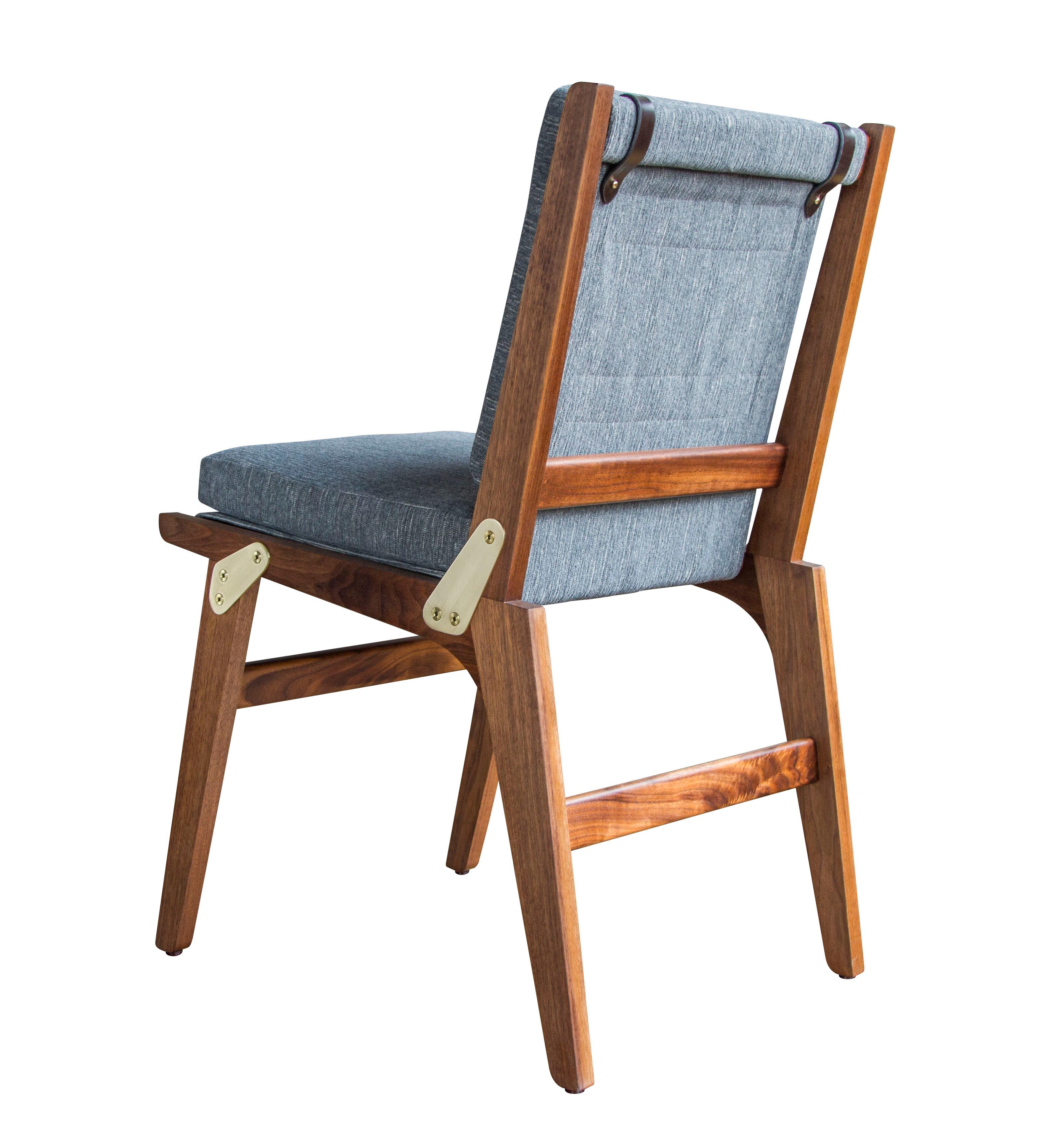 The Officer's Field Set dining chair is shown in oiled walnut, lacquered satin brass and Perennials Fairhaven / Pumice upholstery with dark chocolate English bridle leather accenting straps, and in the non-folding version. 

The modern campaign