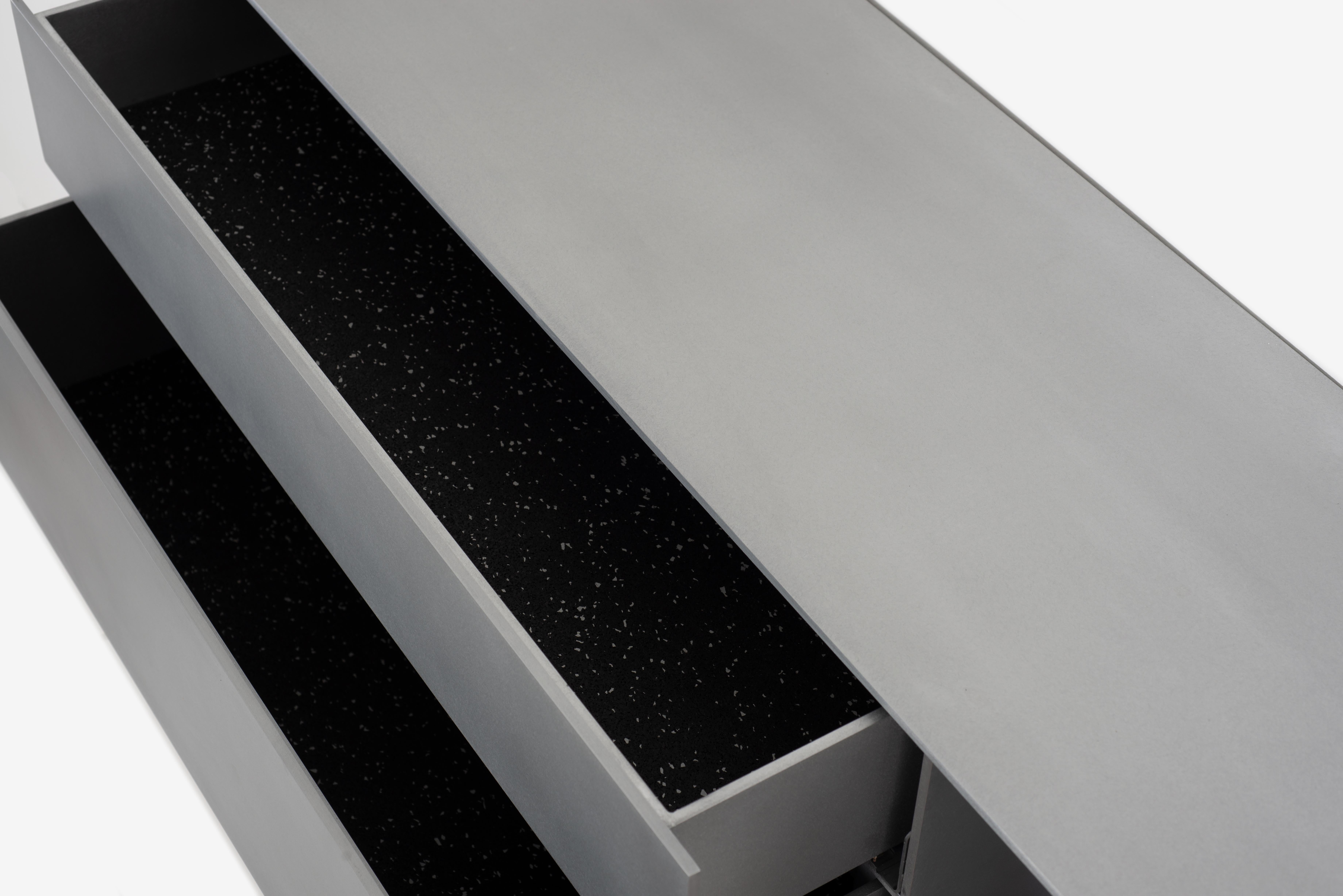 L'étagère murale Minimalist G est sculptée dans un aluminium de 1/4 de pouce d'épaisseur, poli à la cire, avec deux tiroirs dotés de patins à fermeture douce Blum motion. Chaque tiroir est garni de feutre 100% laine ou de caoutchouc noir découpé.