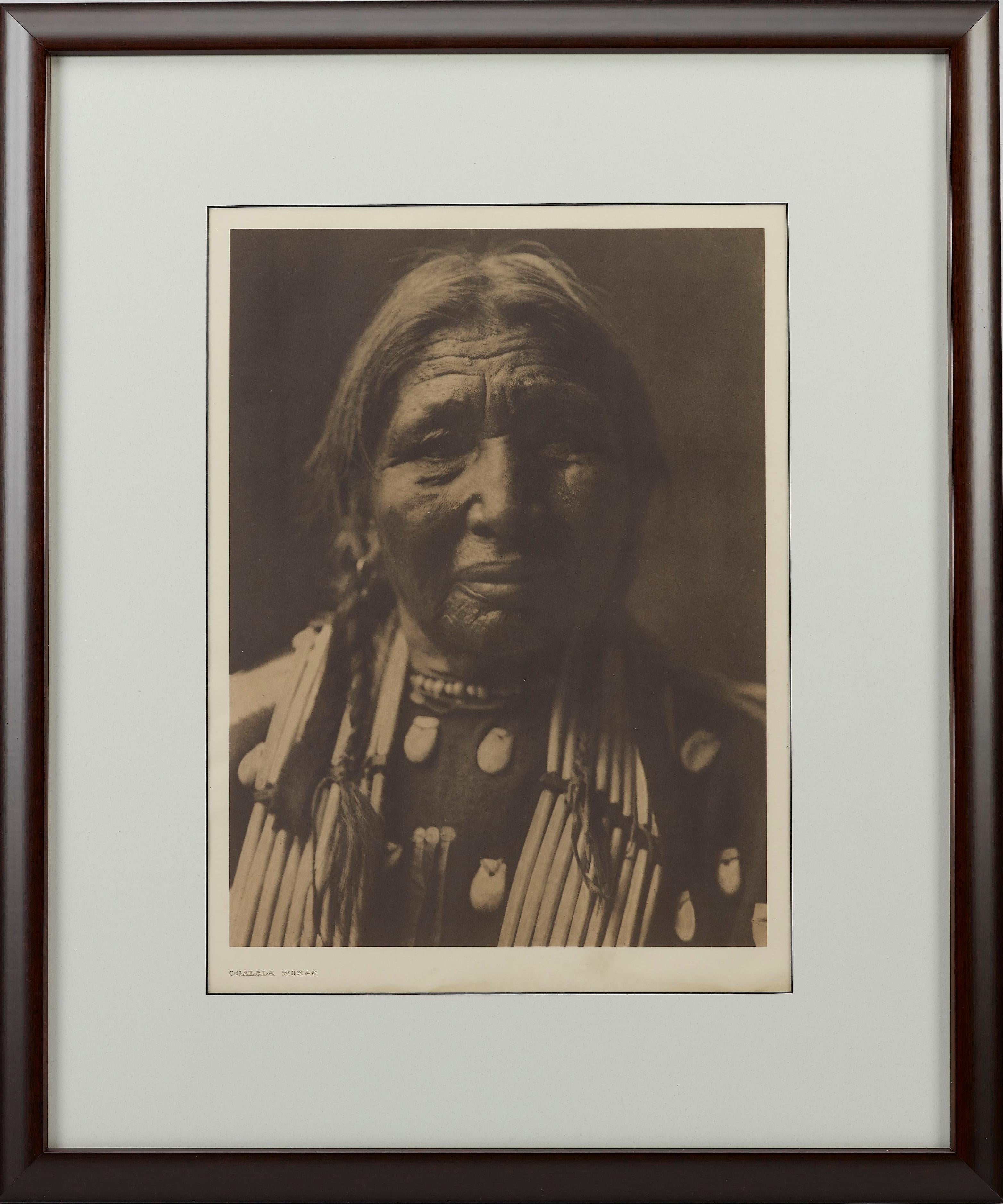 Viene presentato un bel ritratto in fotoincisione di una donna Ogalala di Edward Curtis. L'immagine è la lastra 94 del Portfolio Supplementare 3 del progetto epico di Edward Curtis The North American Indian. La didascalia fornita da Curtis per