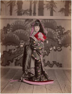 Antique Japan – A costumed Geisha on stage - hand-colored photograph