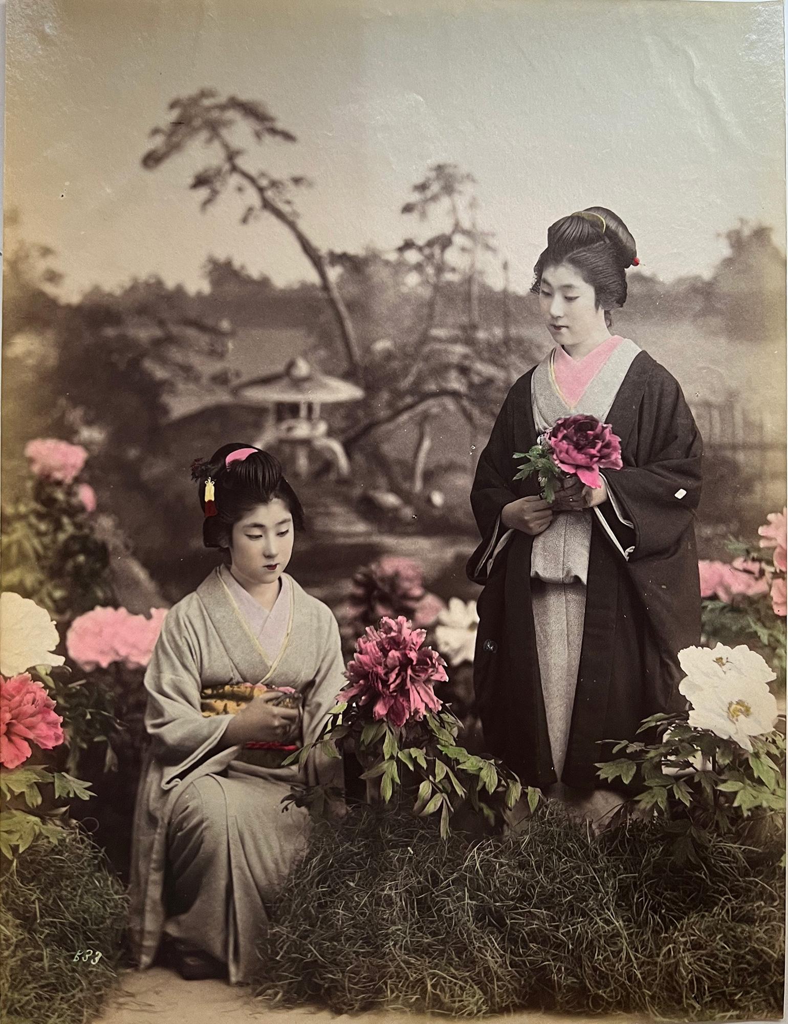 Japan – Two young geishas in flower garden, studio photograph, hand-colored