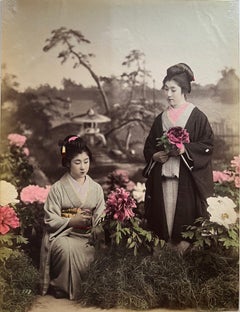 Antique Japan – Two young geishas in flower garden, studio photograph, hand-colored