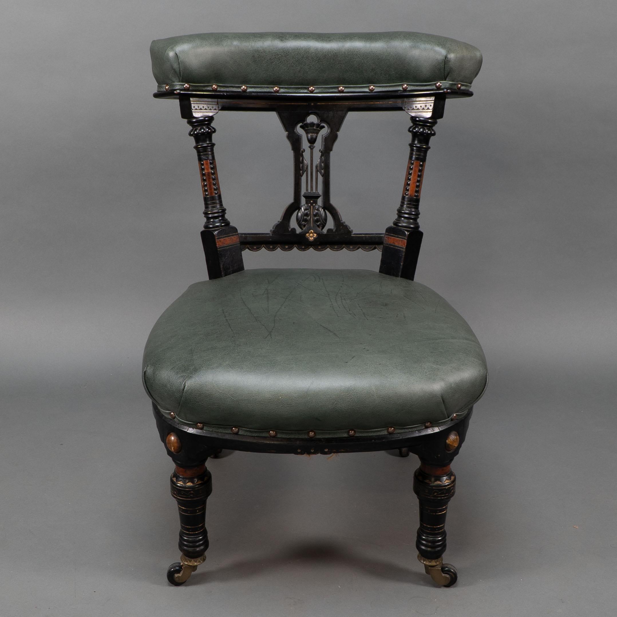 Ogdens of Manchester, in the style Dr Christopher Dresser.
Aesthetic Movement ebonized and parcel gilt walnut nursing chair, with a carved lotus flower, and ring-turned legs with original brass and ceramic casters, the casters stamped with a Patent