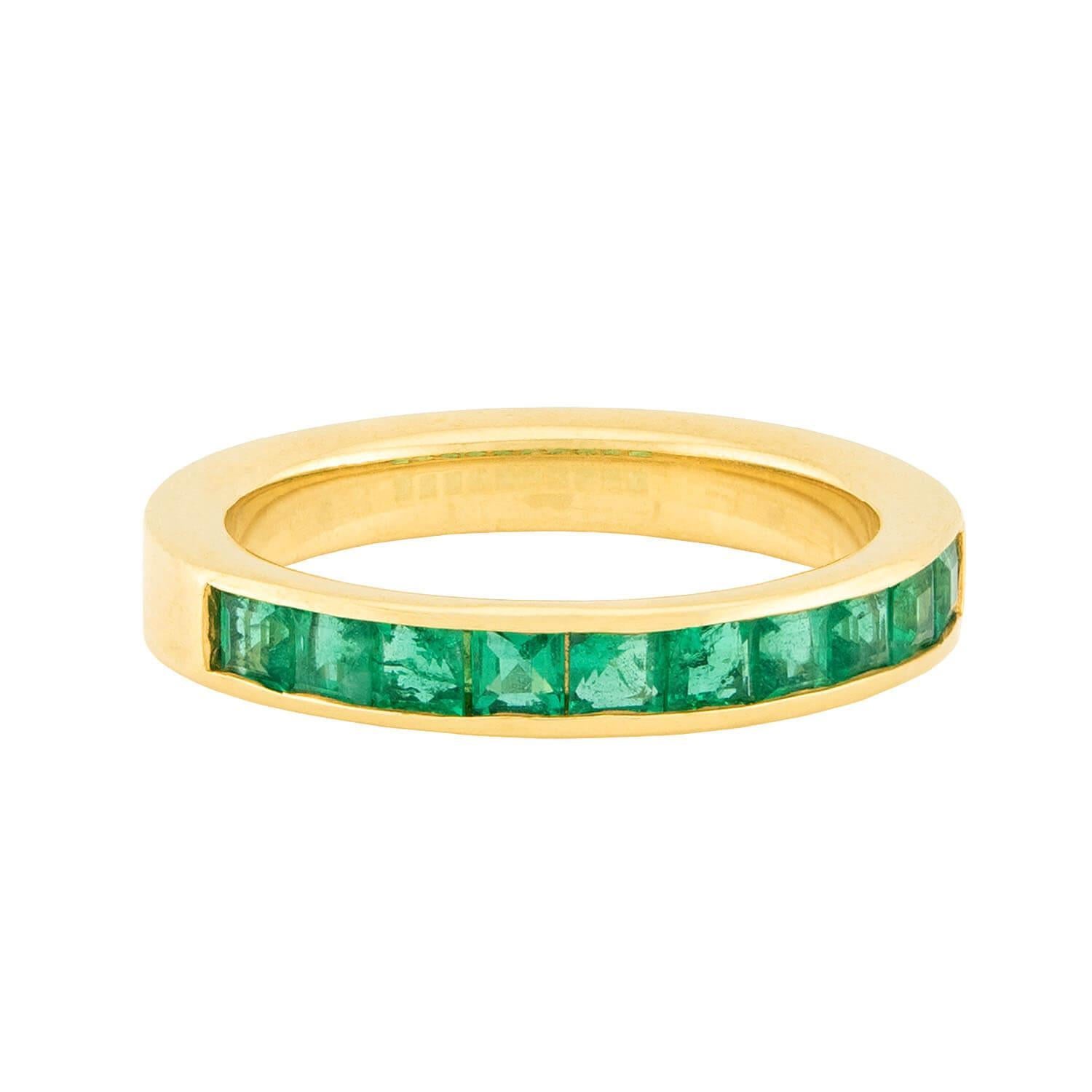 Una fascia di smeraldi assolutamente splendida del gioielliere OGI! Realizzato in vibrante oro giallo 18 carati, questo anello presenta una fila di 10 smeraldi a taglio quadrato, tutti incastonati. Gli smeraldi hanno una tonalità verde brillante e