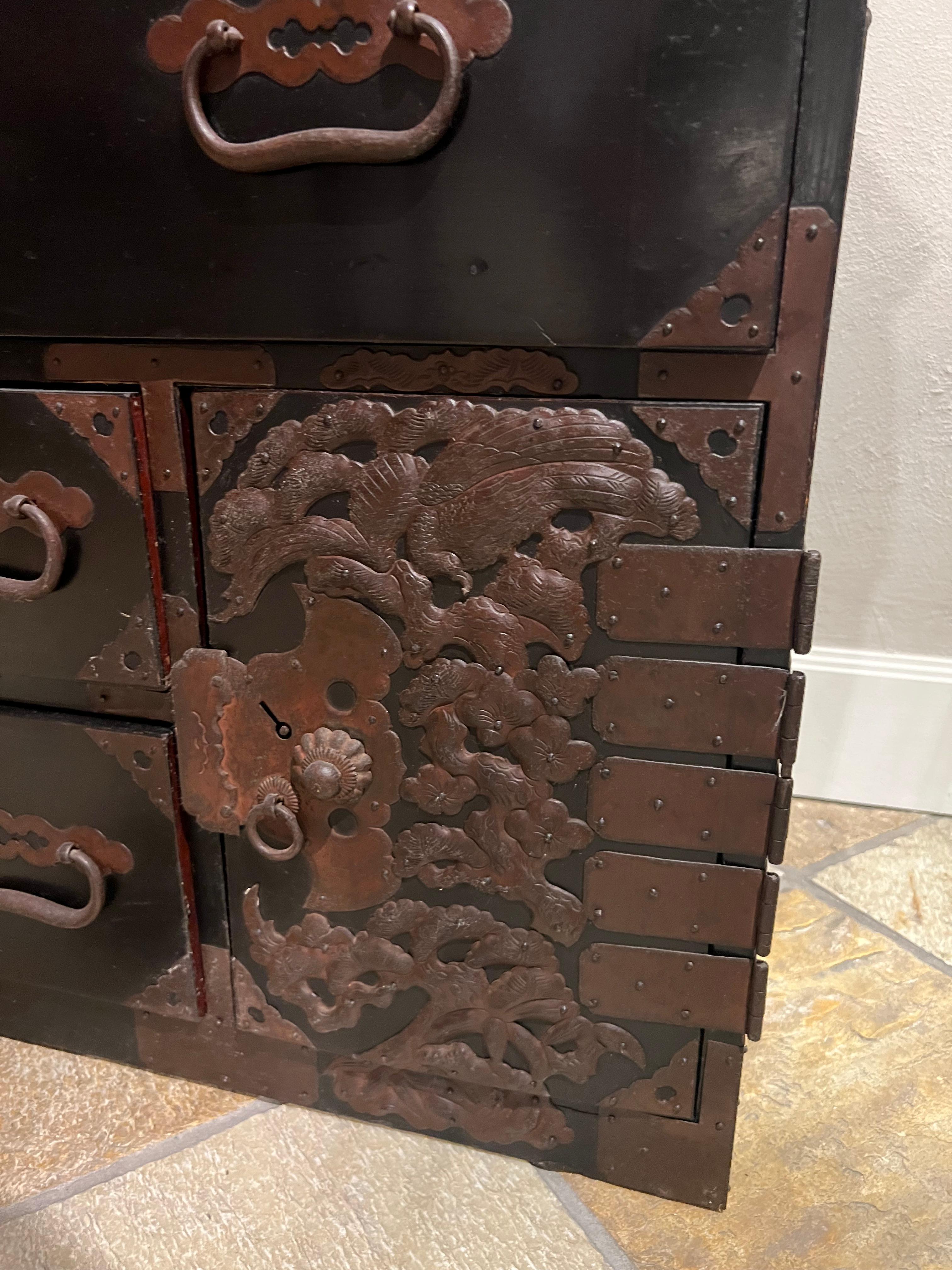 This early 20th century Japanese clothing chest from Sado Island produced in the late Meiji Era. It consists of two pieces decorated with very elaborate metalwork covering the front.
It consists of two overlapping parts that can be easily separated