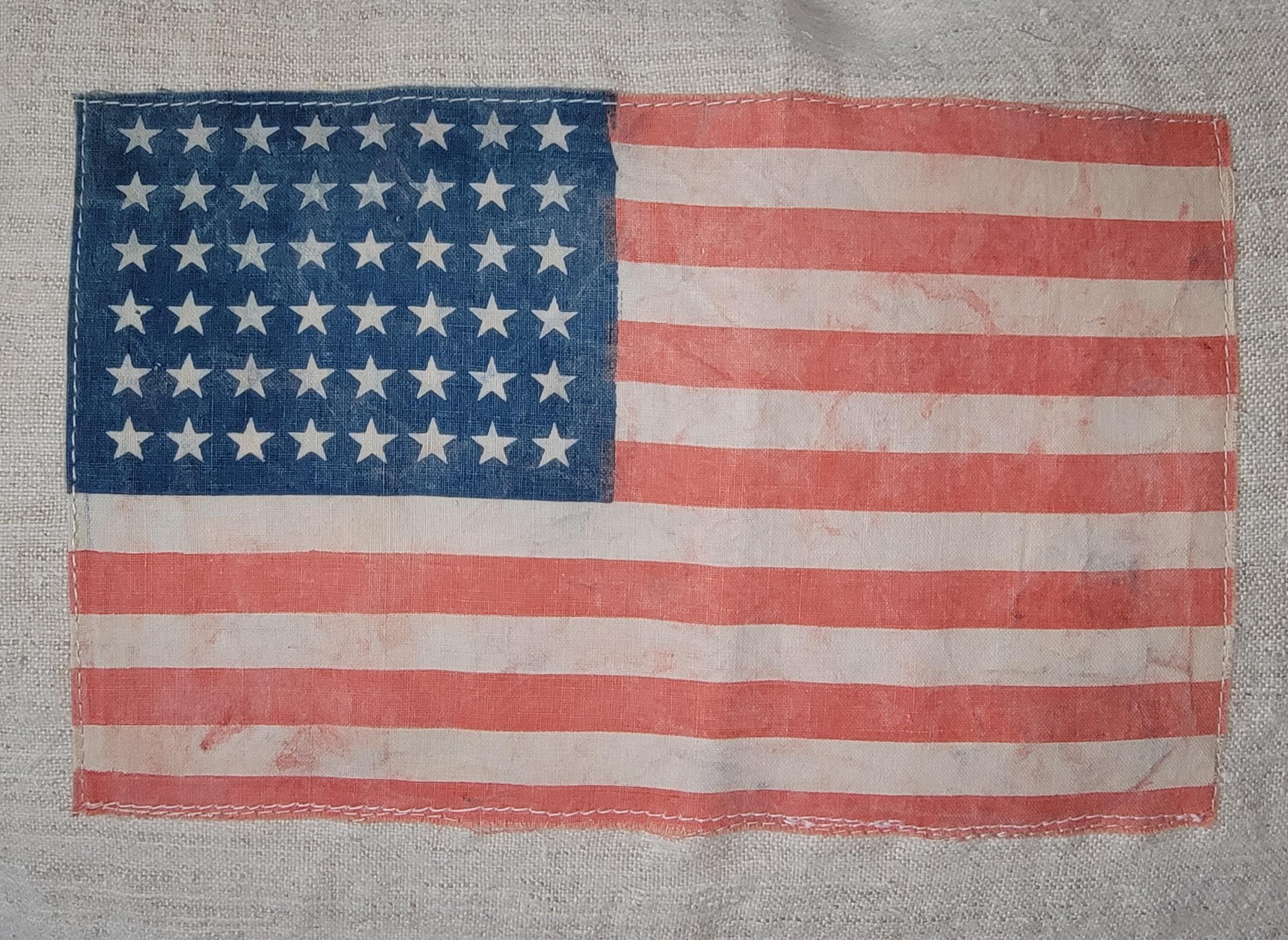 Early 20thc Oils cloth sewn onto linen. This is 48 star flag, a small vintage linen parade flag. The 48 stars signify the adoption of Arizona and New Mexico into the united states. Great small piece of history. 