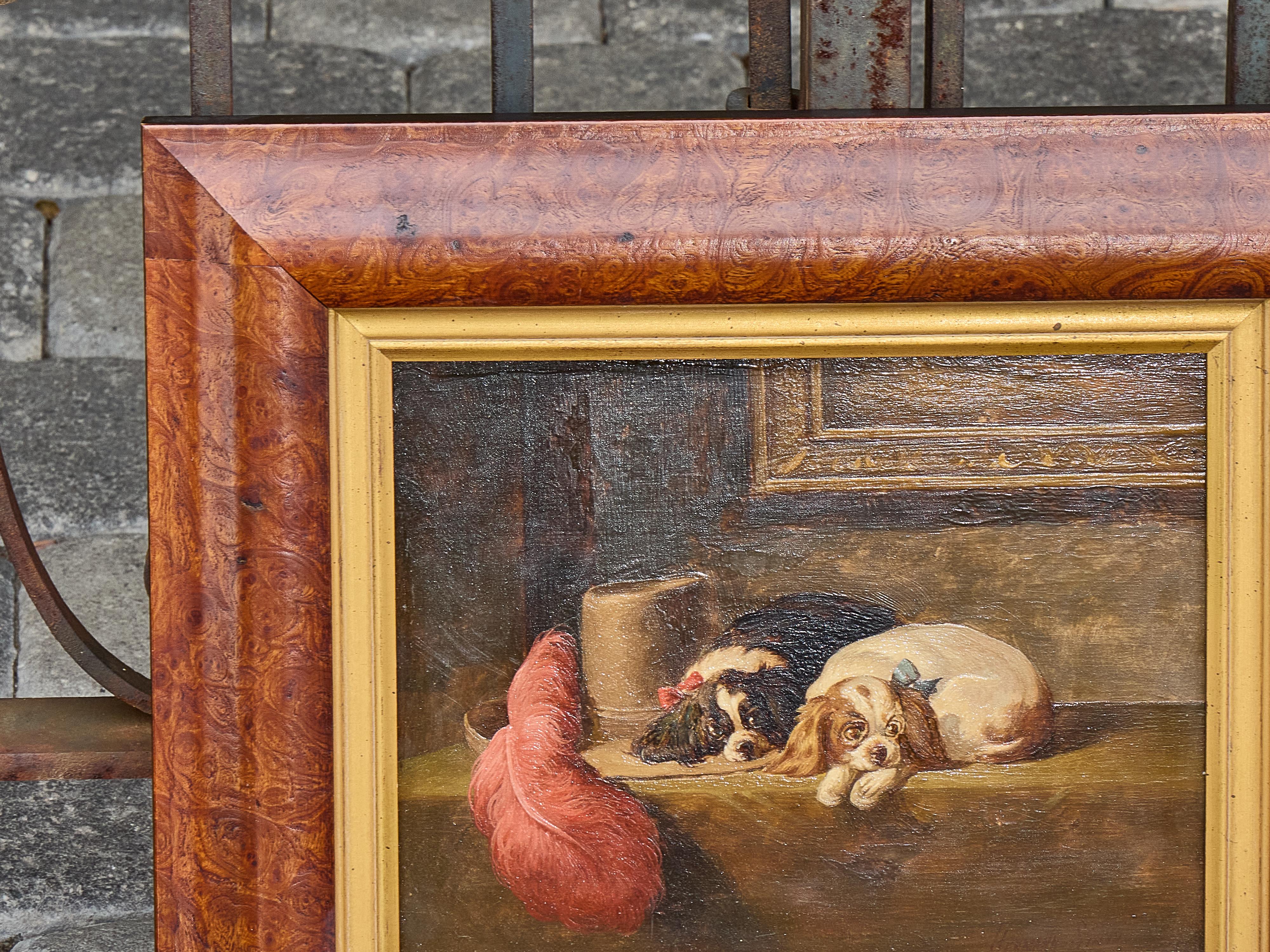 Charmante huile sur panneau de la fin du XIXe siècle représentant deux épagneuls King Charles nichés dans un intérieur richement aménagé, peinte à la manière de Sir Edwin Landseer. Exécutée vers 1880-1900, cette œuvre anglaise capture le tempérament