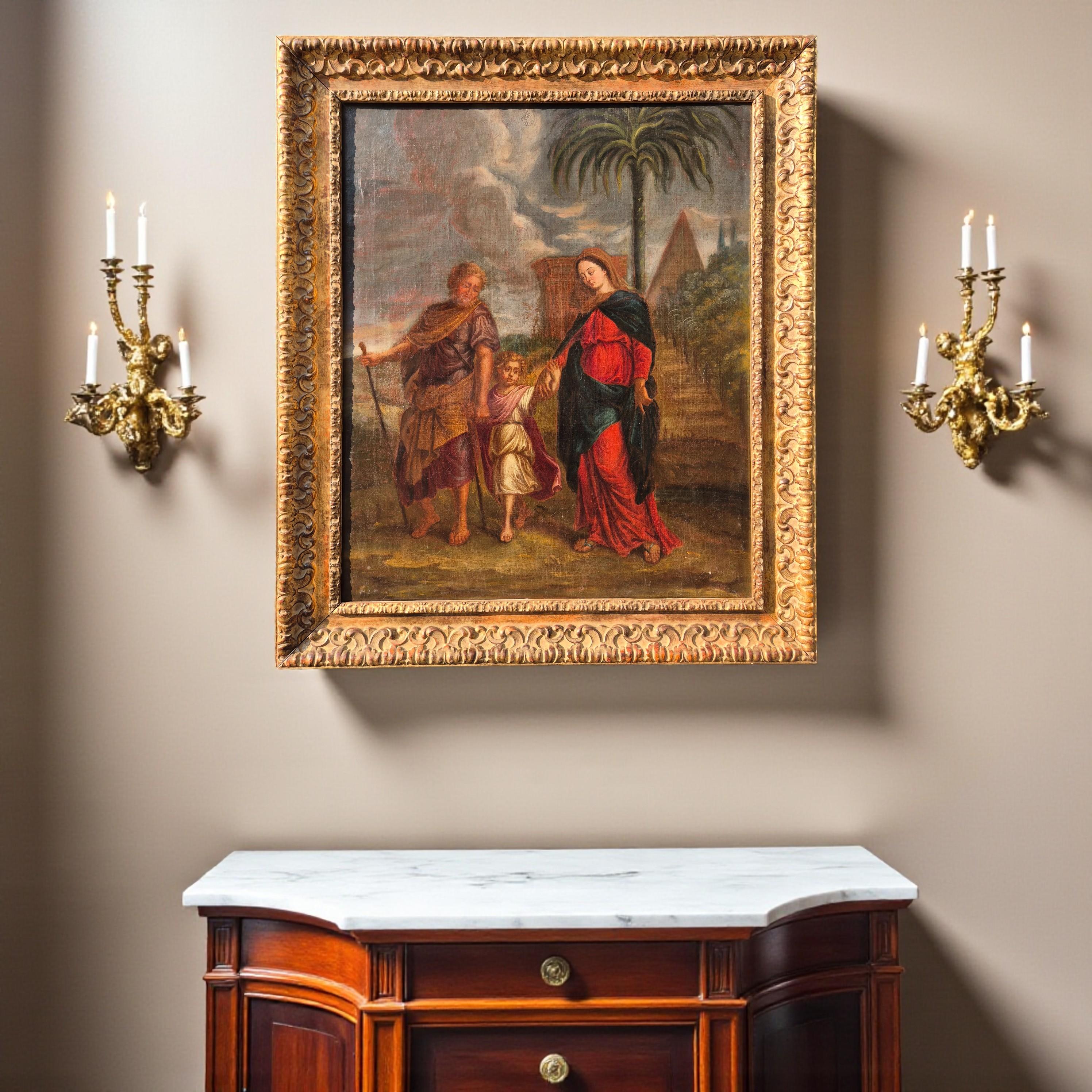 Elegant 17th-century oil on canvas depicting the Return from Egypt, a deeply spiritual and tender representation of the Holy Family.

At the heart of the composition, the Virgin Mary, dressed in a flowing red robe and a dark blue mantle, gently