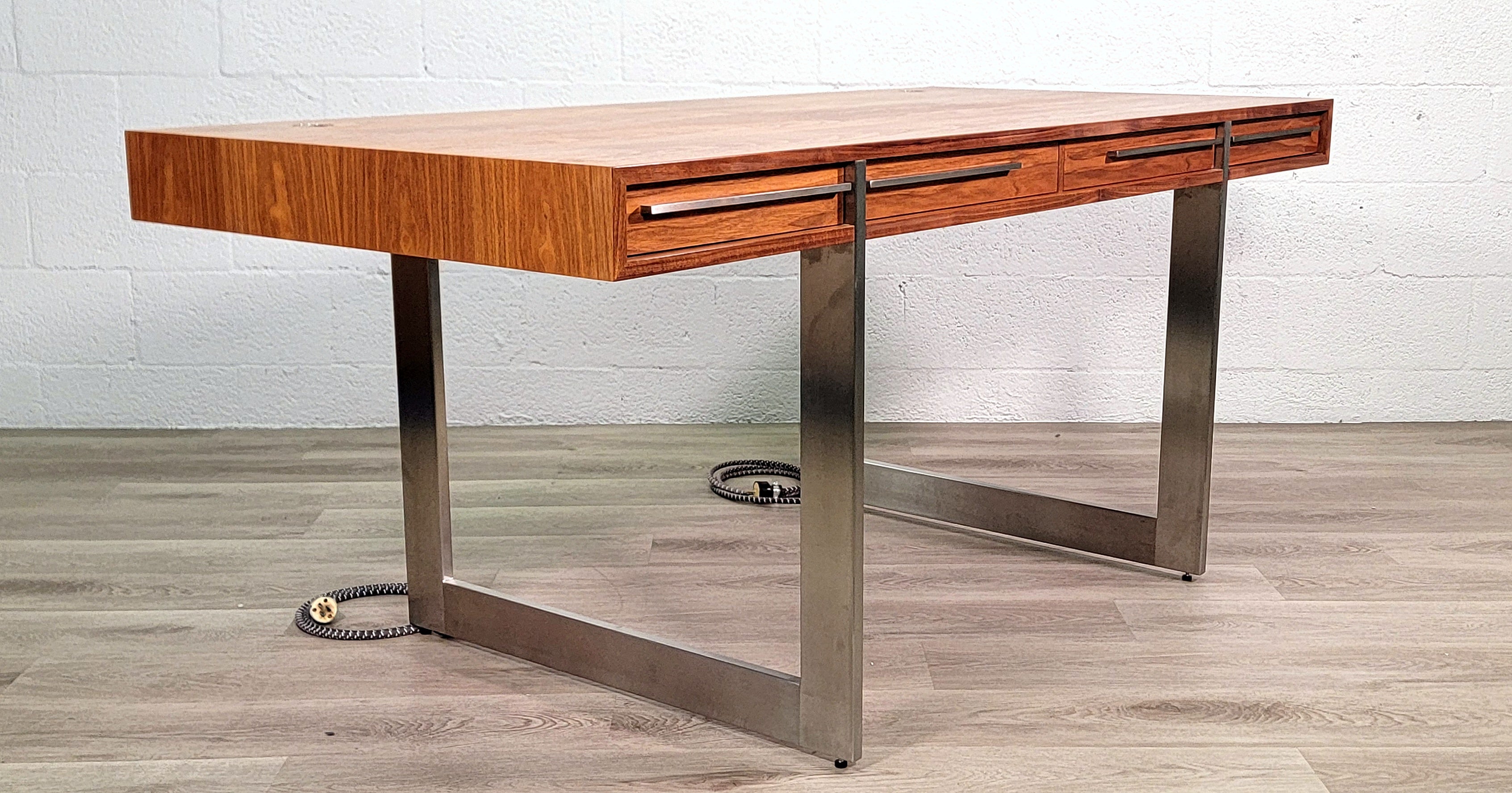 This beautiful desk is modern furniture at its finest. Make a statement in any office. The solid walnut wood top of this desk is supported by an elegant stainless steel frame. Top includes drawers with organization for all the little necessities.