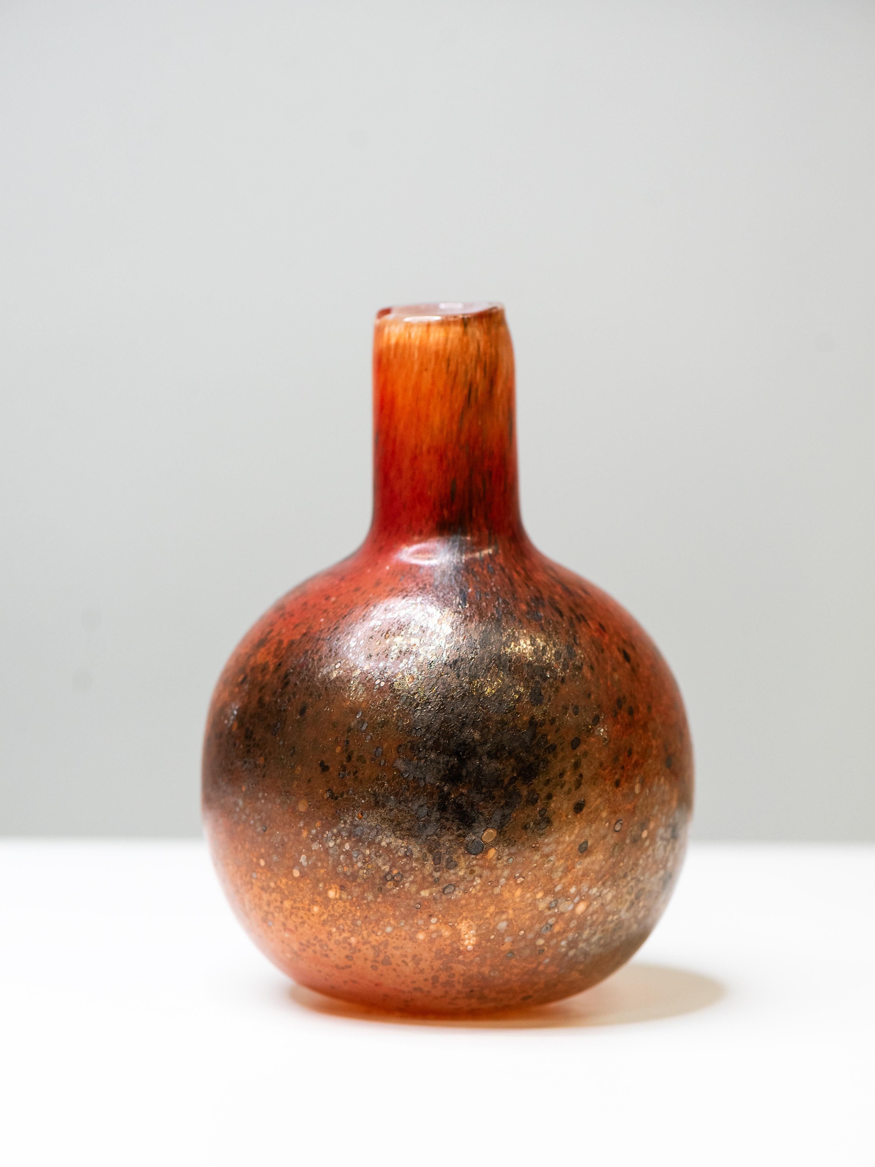 Una atrevida y gruesa pieza de vidrio soplado a mano de la serie Tunturissa (En las colinas) de Oiva Toikka, producida por Nuutajärvi en la década de 1980. Cada obra de la serie es única, y esta versión de la botella Ruska muestra una mezcla