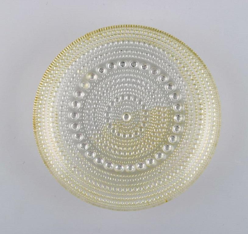 Oiva Toikka für Arabien. Zwei Kastehelmi-Teller und vier Flaschentabletts. 
Finnisches Kunstglas, 1970er Jahre.
Die Platte misst: 14 x 2,2 cm.
In ausgezeichnetem Zustand.