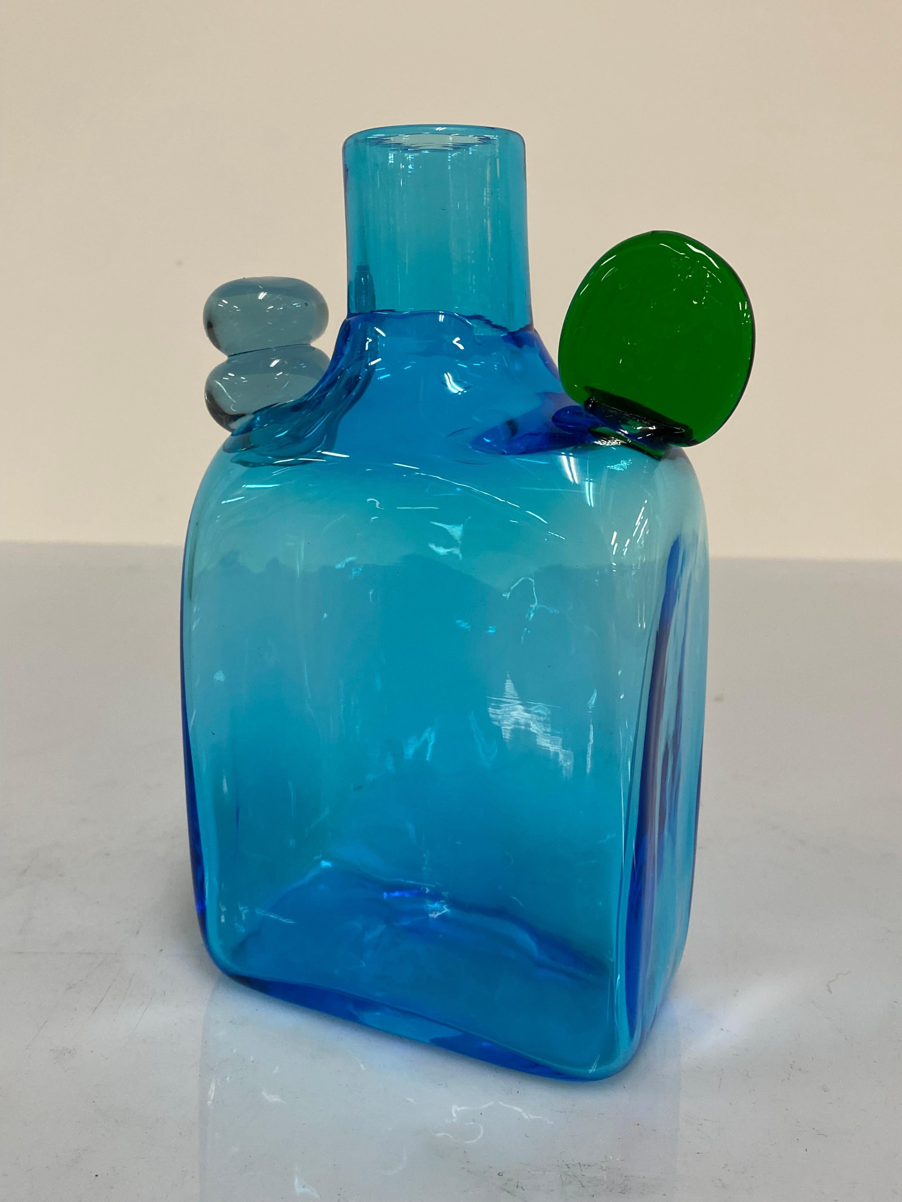 Diese leuchtend blaue Pampula-Flasche mit grünen und klaren Glasdetails von Oiva Toikka ist eine perfekte Dekoration für sich allein. Der Gesamtzustand dieses verspielten Kunstwerks ist sehr gut und es ist mit der Inschrift Oiva Toikka Nuutajärvi