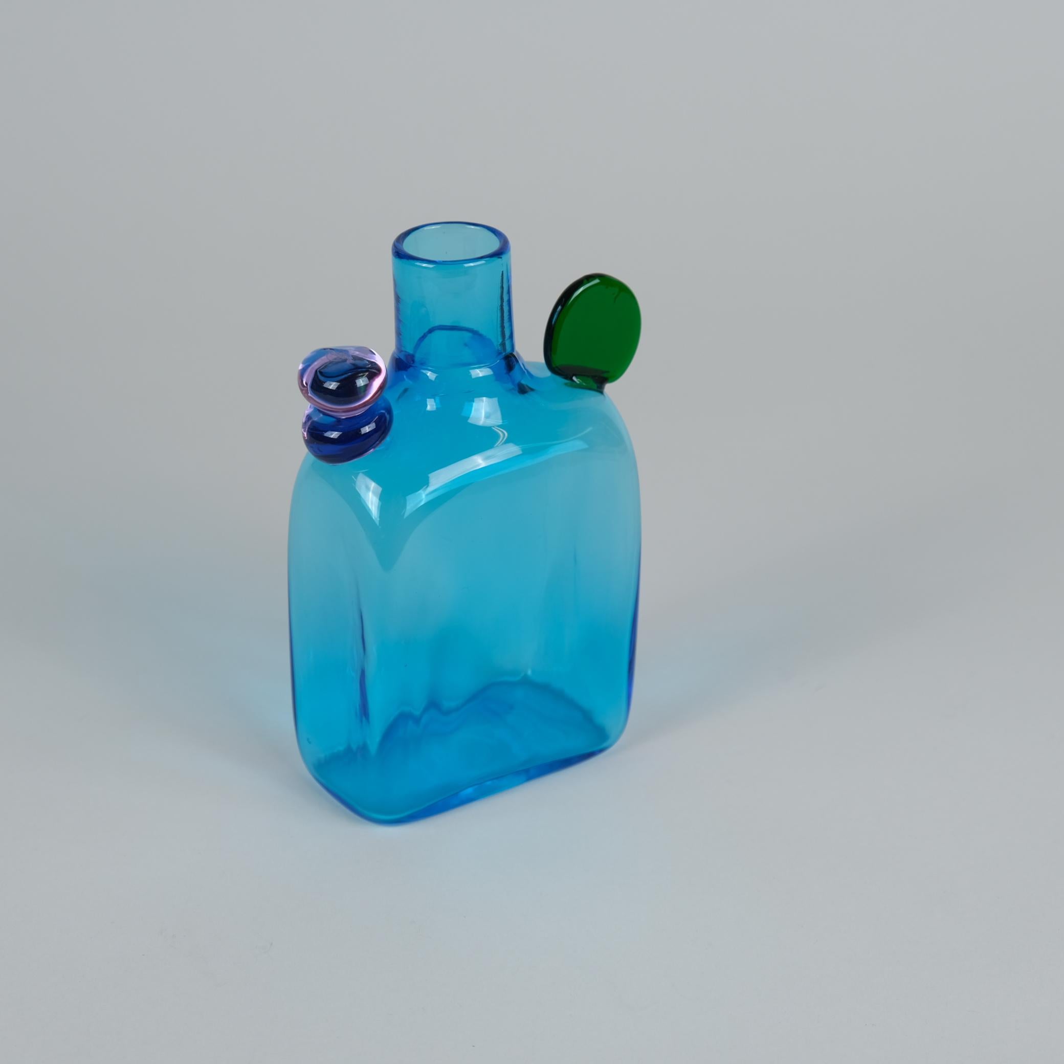 Questa bottiglia Pampula blu con dettagli in vetro verde e trasparente di Oiva Toikka è una decorazione perfetta da sola. Le condizioni generali di questa opera d'arte ludica sono molto buone ed è accompagnata dall'iscrizione Oiva Toikka Nuutajärvi