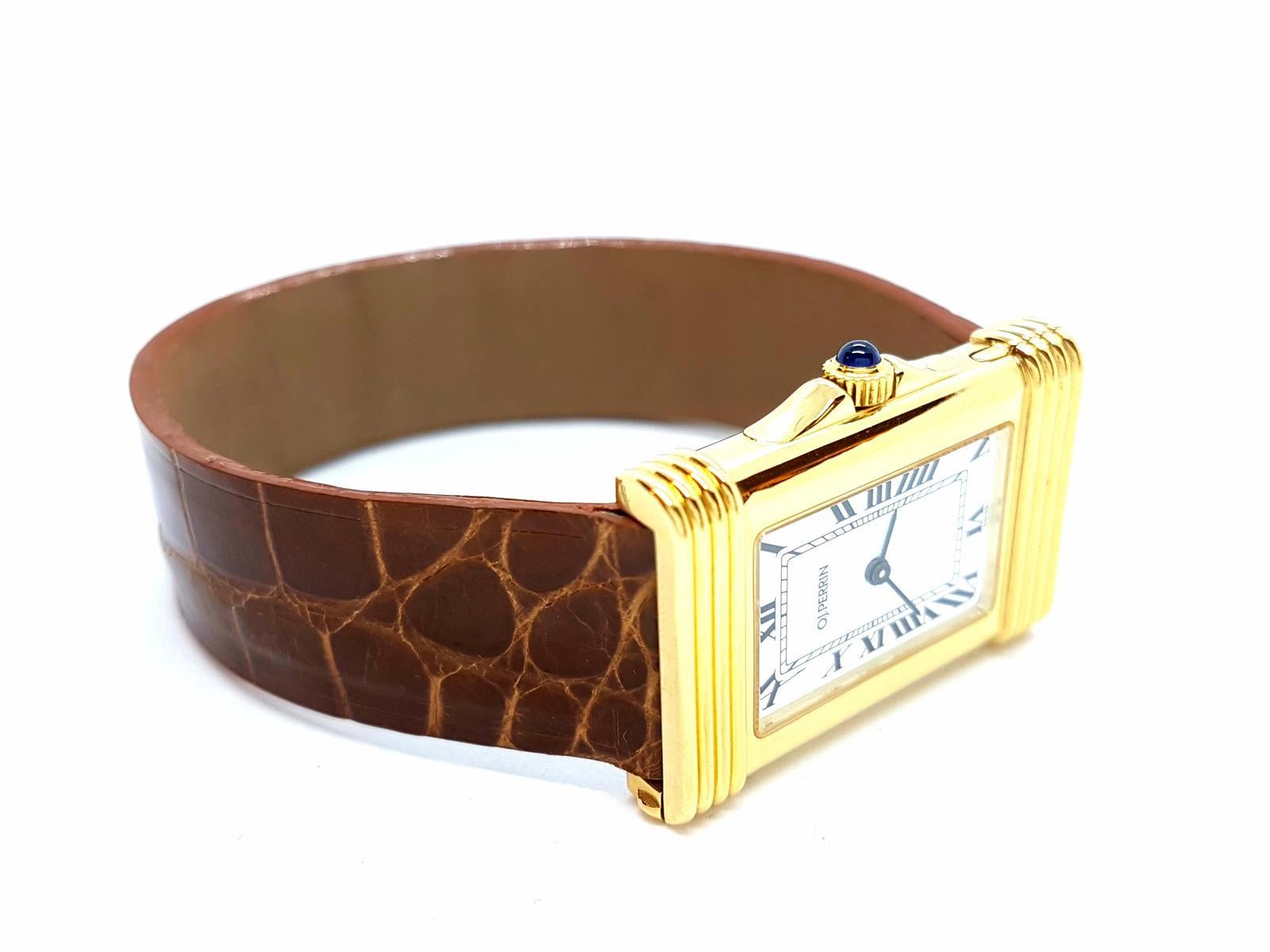 Uhr signiert das Haus OJ Perrin. Quarzwerk. Gelbgoldgehäuse 750 Tausendstel (18 Karat). Krokodillederarmband. Gehäusegröße: 2,1 cm x 3,2 cm. Handgelenkgröße: 18cm (Armbandlänge aus Zifferblatt 14,8 cm) Breite Armband: 1,6 cm. weißes Zifferblatt.