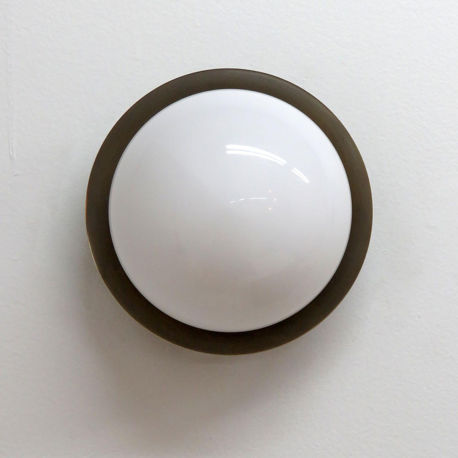 wonderful wall lights designed by Gallery L7, handcrafted and finished in Los Angeles from American brass, with center opaline glass shade on an aged raw brass disc. Available with gloss or satin glass shade (extra charge for satin shade). One E12